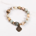 Bracelet with multicolored beads and a metal charm on a white background.