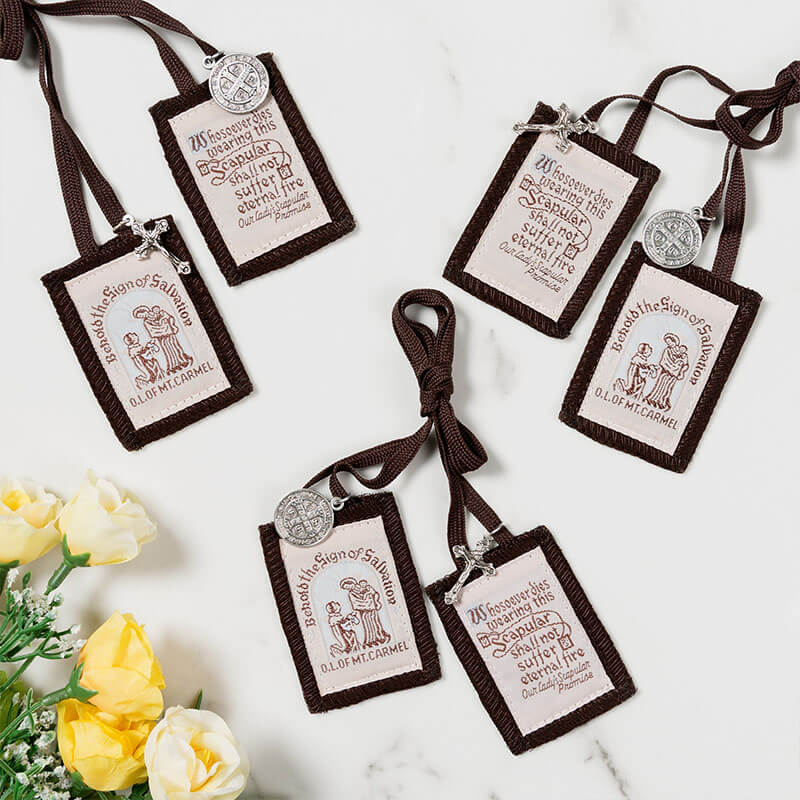 Three brown scapulars on a marble surface with yellow flowers.