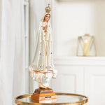 Statue of the religious figure, Fatima, with a crown on a reflective surface.