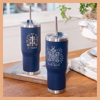 Two navy blue tumblers with designs on a wooden surface.