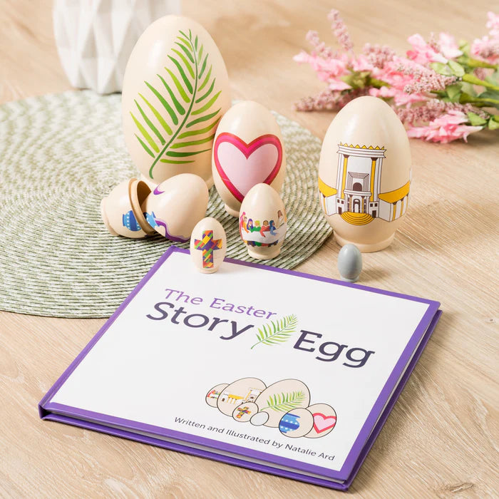Decorative Easter eggs with colorful designs on a wooden surface next to a book titled 'The Easter Story Egg'.