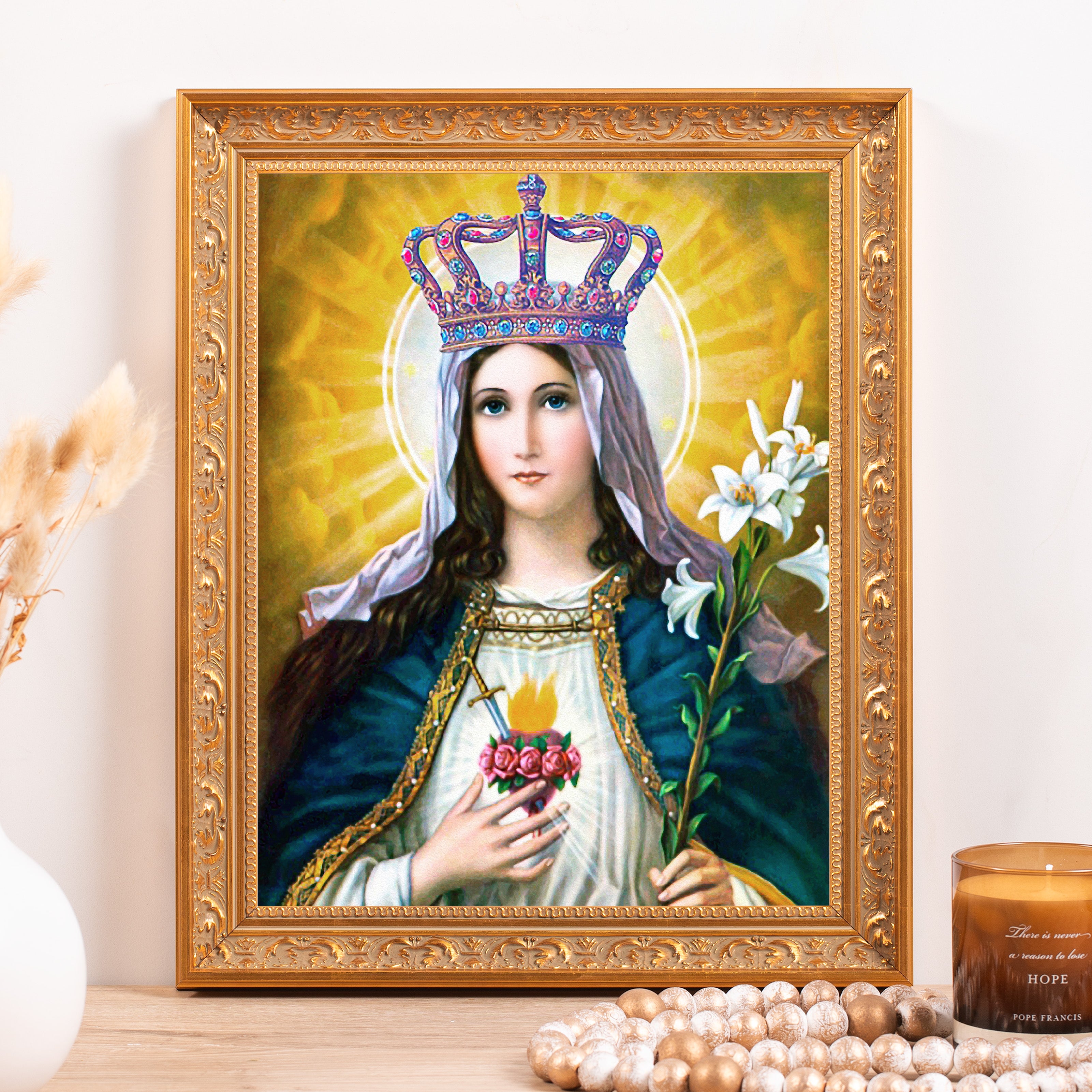 Framed art of Mary in blue and gold with a crown and flowers, ornate frame.