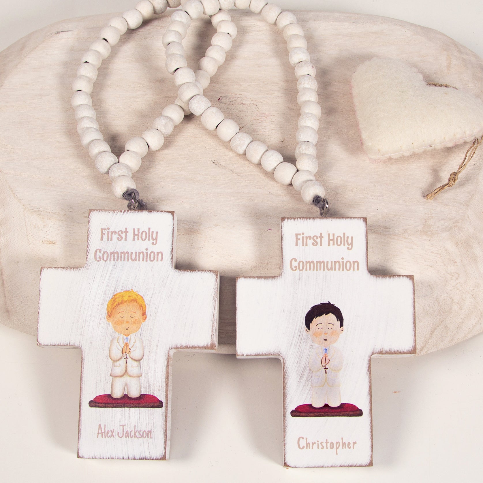 Wooden crosses commemorate First Holy Communion with beaded necklace, featuring child illustrations and personalization.
