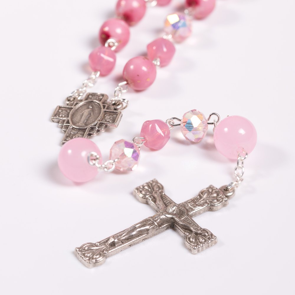 Pink beaded rosary featuring a silver cross and centerpiece for prayer and meditation.