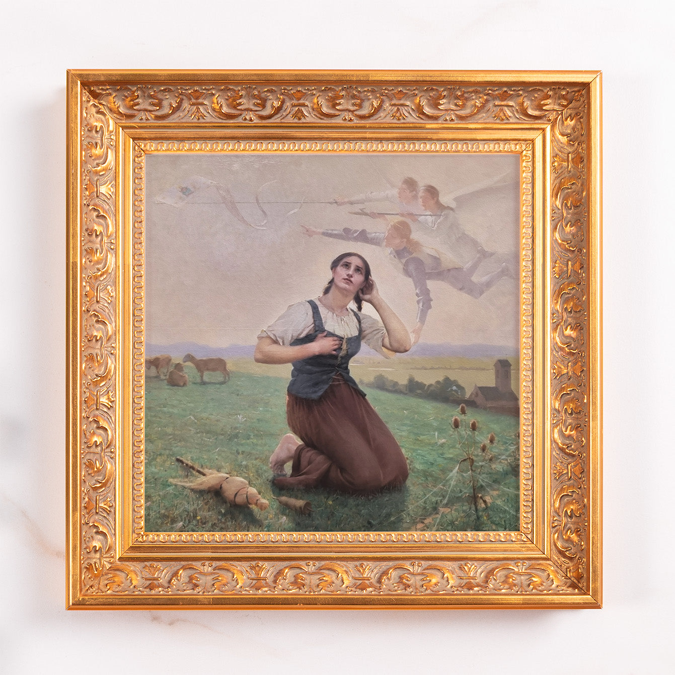 Framed art print depicts a kneeling woman looking up at angels with bows and arrows, painted in an old masters style, in a gold frame.