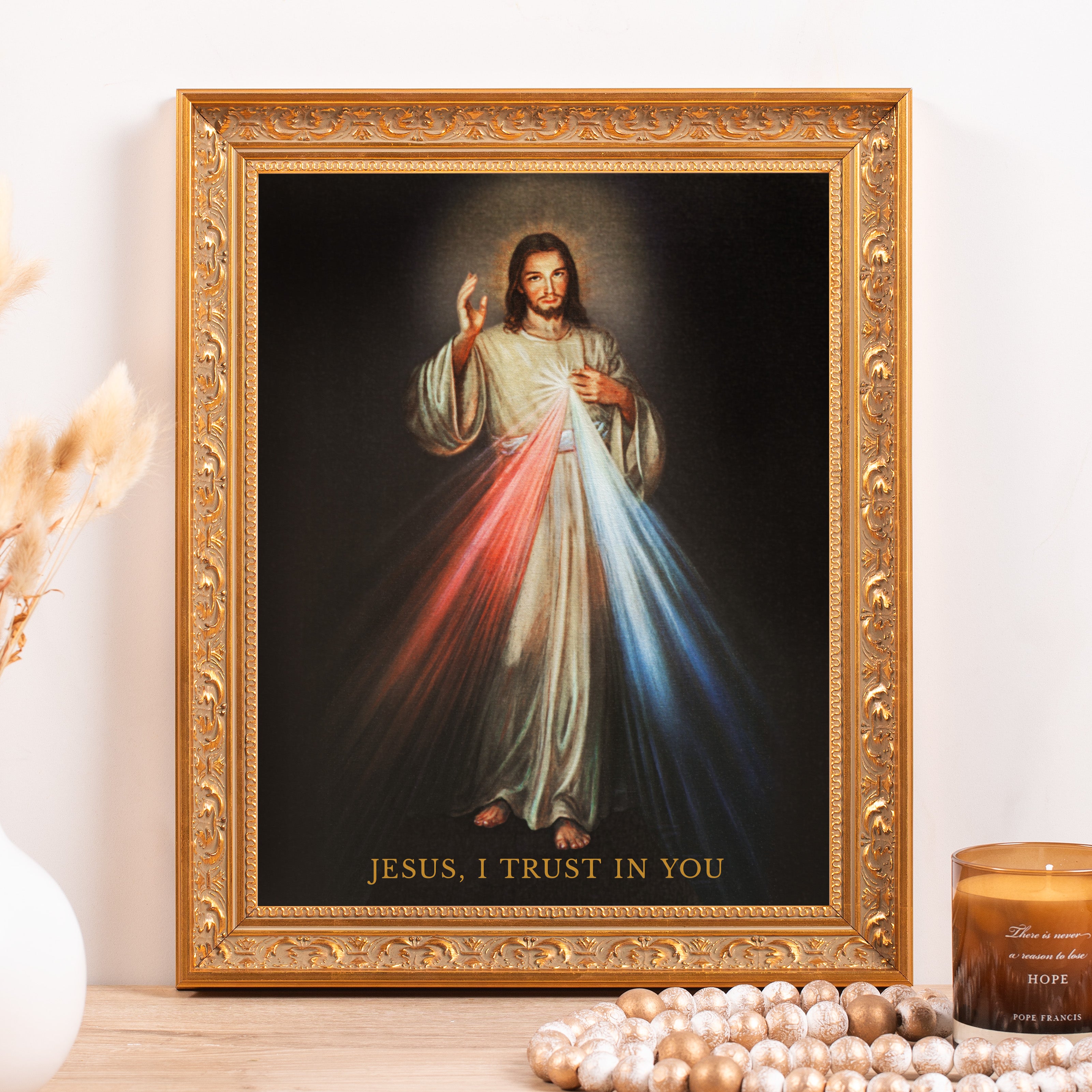 Framed "Jesus, I Trust In You" print with gold ornate frame and black background.