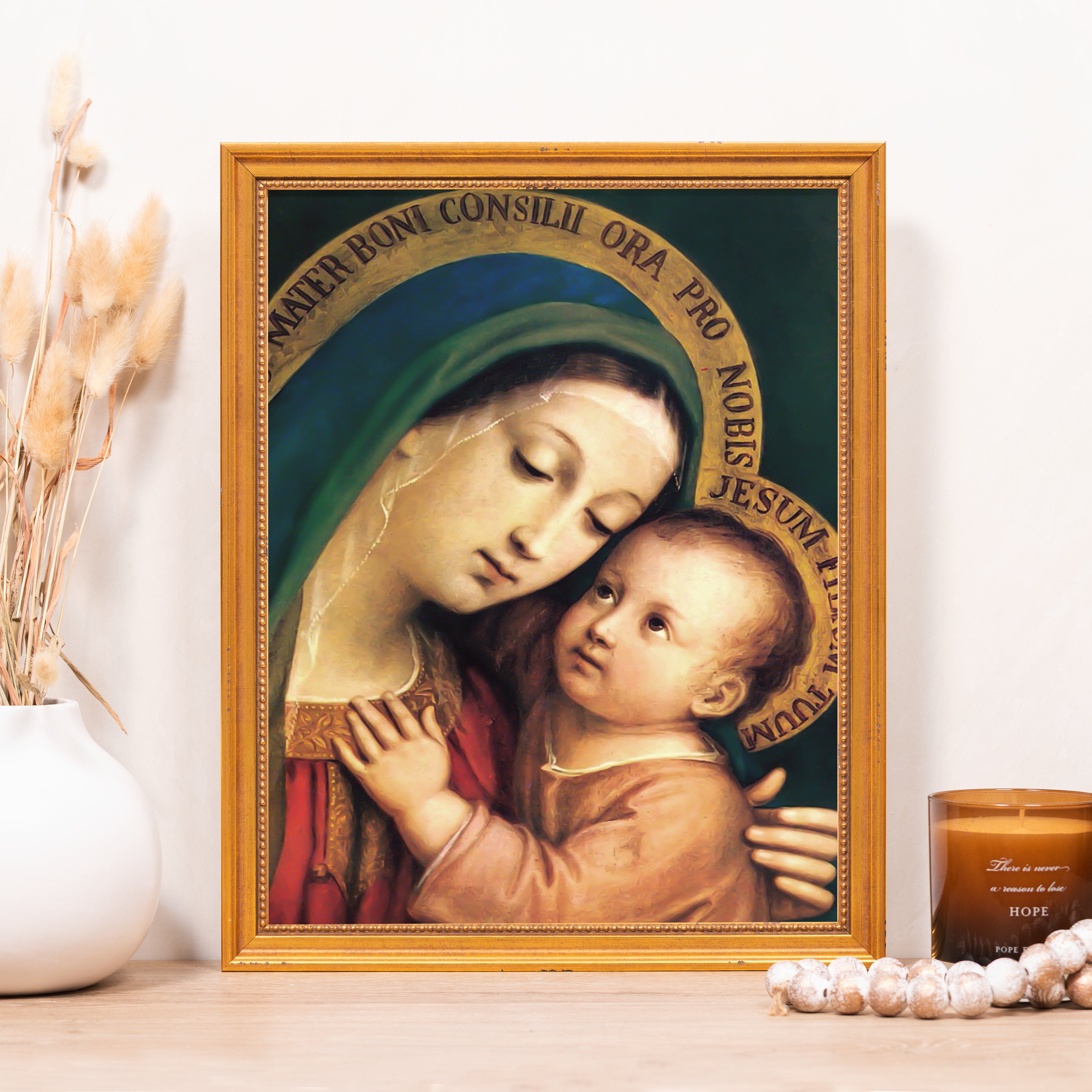 Framed print depicting Mary holding baby Jesus, in gold frame with green, red and gold hues.