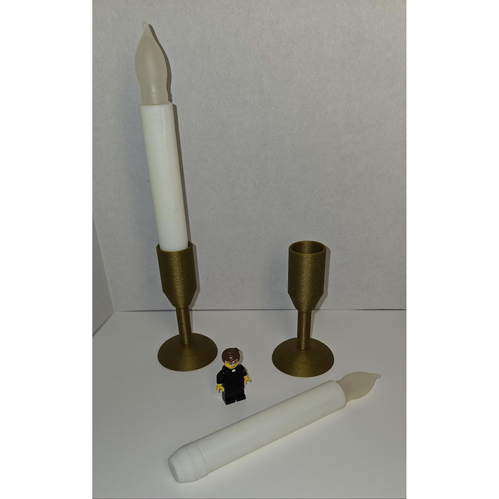 Battery candles with gold, 3D-printed candle holders, next to a Lego figure.