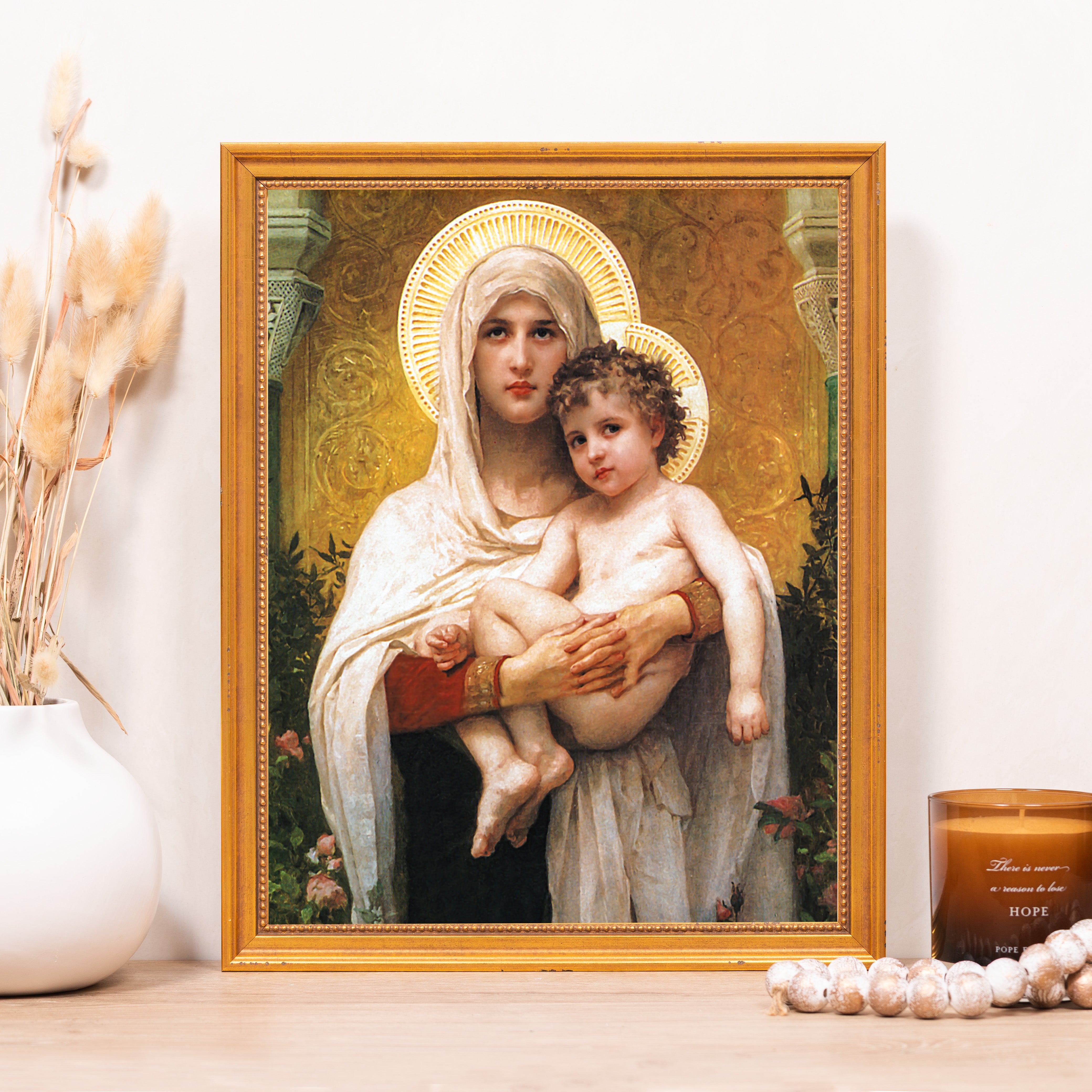 Framed Mary and Jesus print with gold frame; classical-style art depicting mother and child with halos.