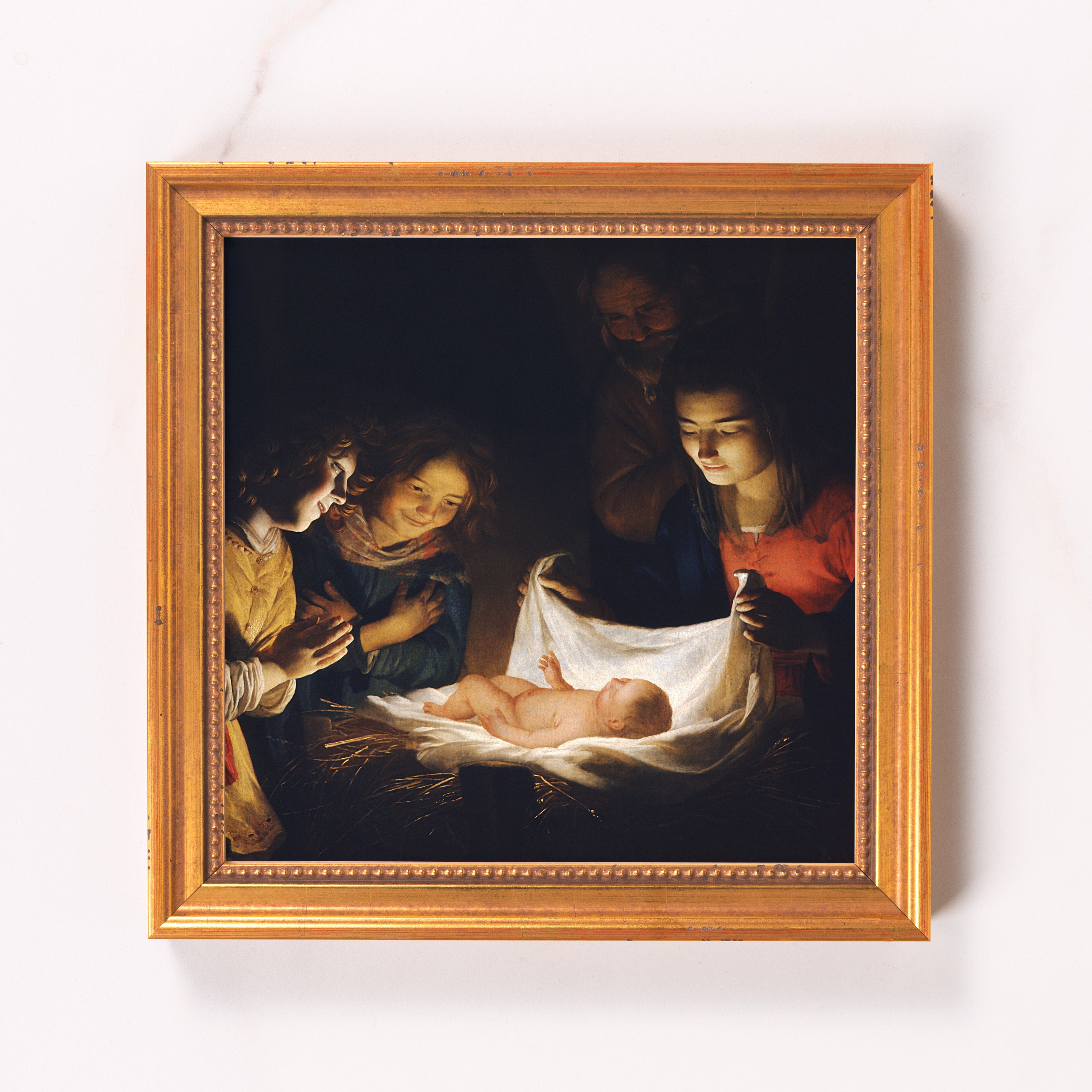 Framed art print of the Nativity scene with golden frame and dark background.