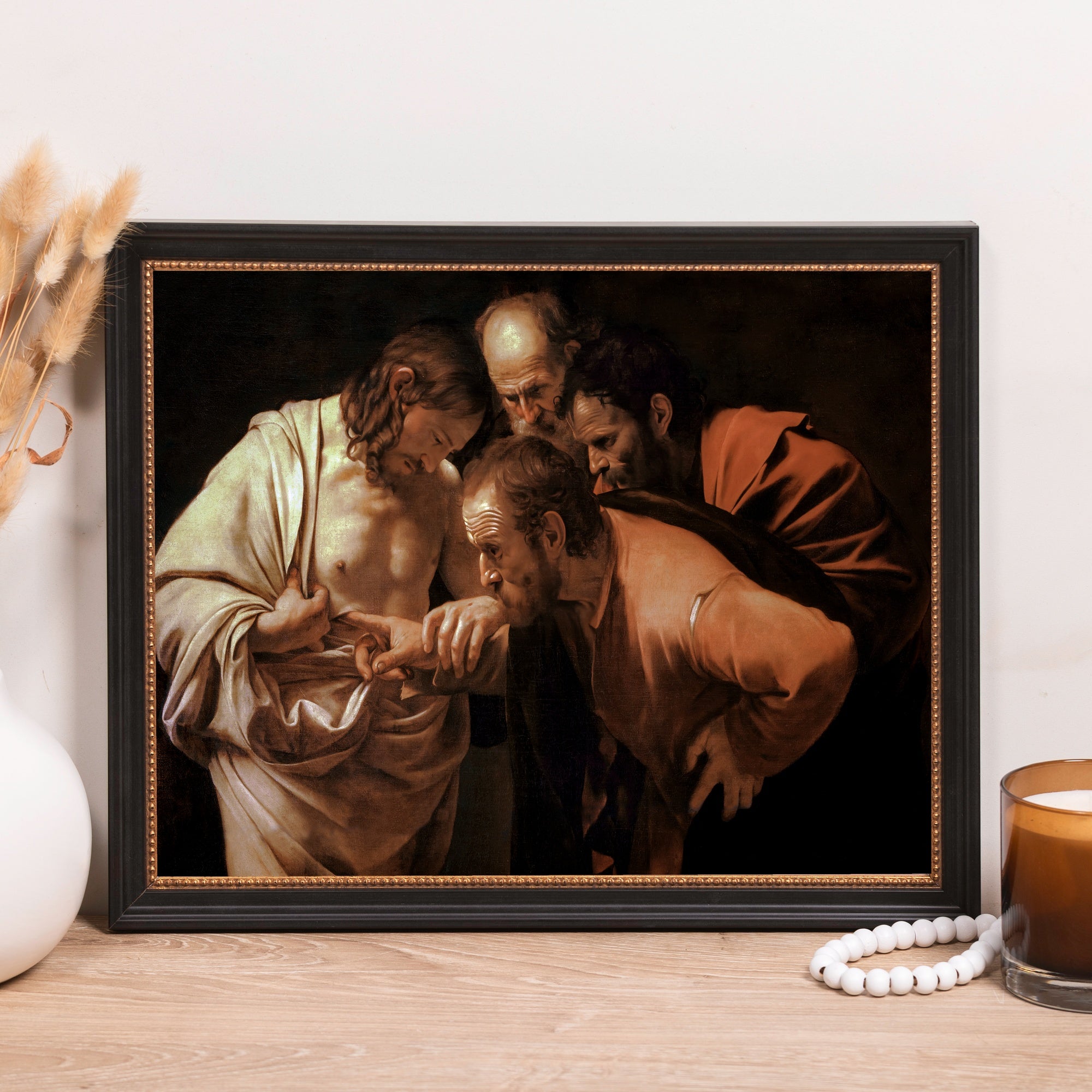 Framed painting of "The Incredulity of Saint Thomas" with a black and gold frame for art display in homes or offices.