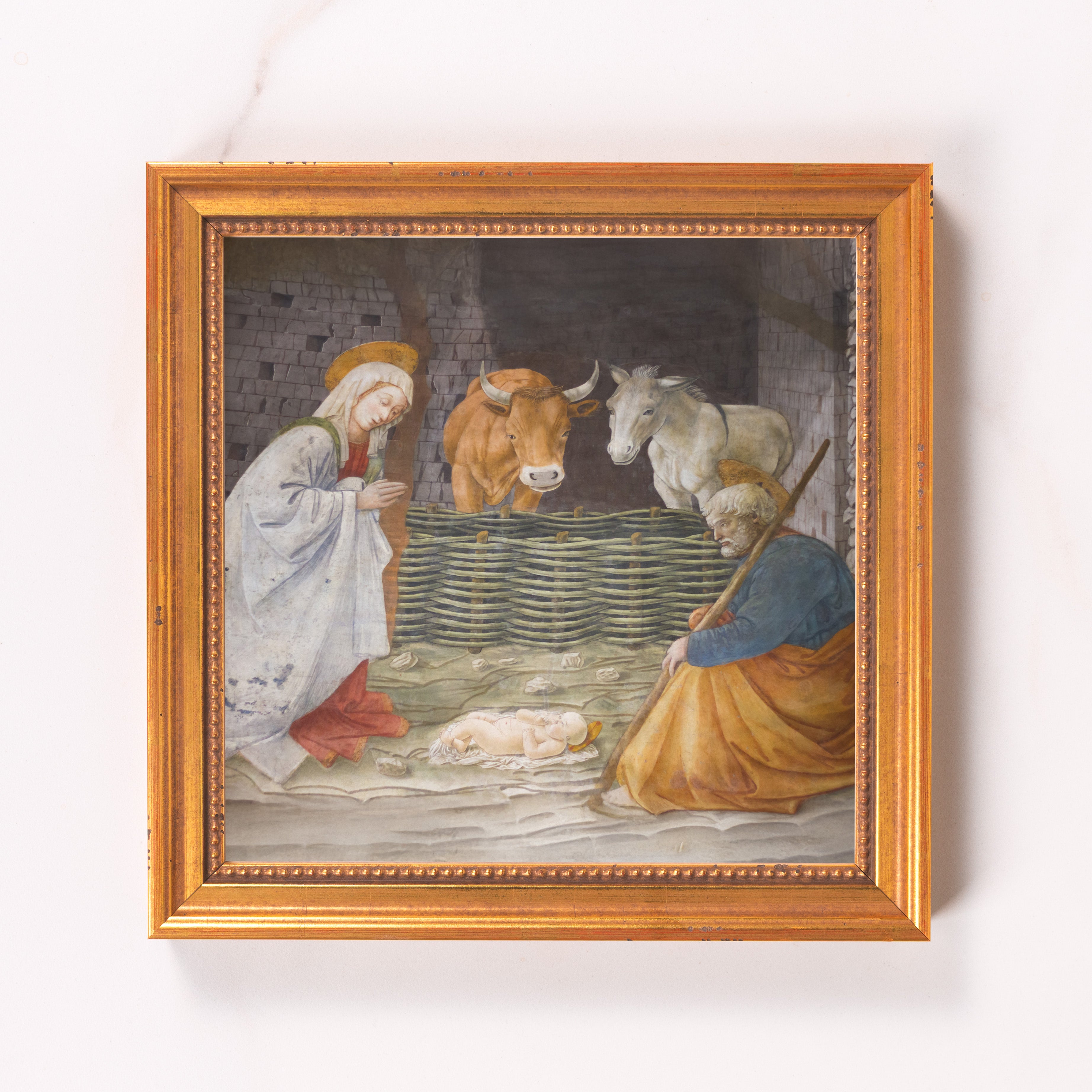 Framed print depicts a Nativity scene in traditional style with a gold-tone frame.