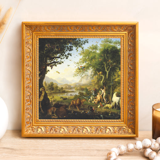 Framed print of paradise with Adam and Eve in lush garden. Gold, ornate frame.
