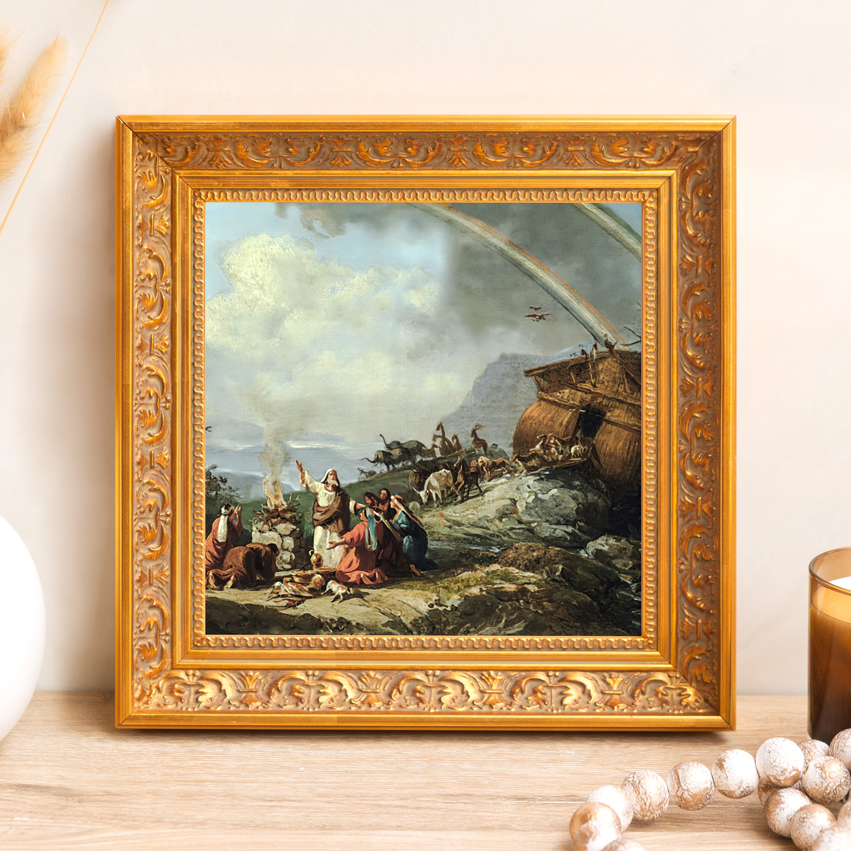 Framed print of Noah's Ark with a gold, ornate frame on a light wood table.