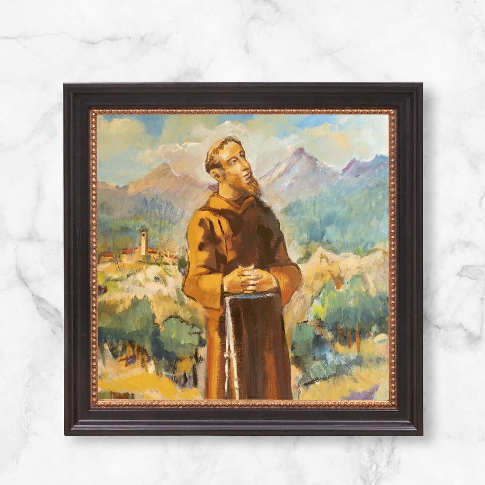 Framed painting of a brown-robed Saint Francis looking up at the sky with mountains in the background.