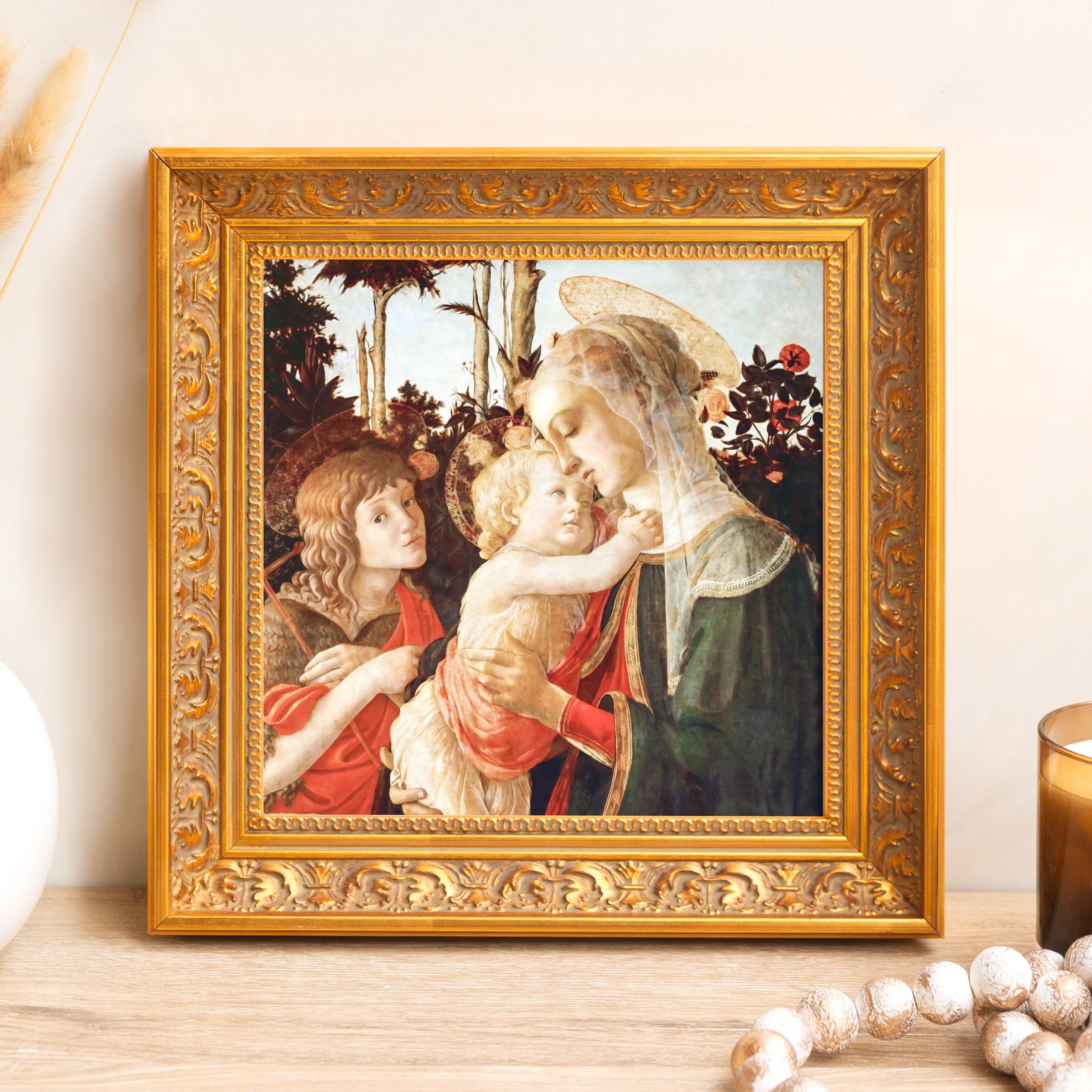 Framed renaissance painting of Madonna and child in an ornate gold frame, displayed on a table.
