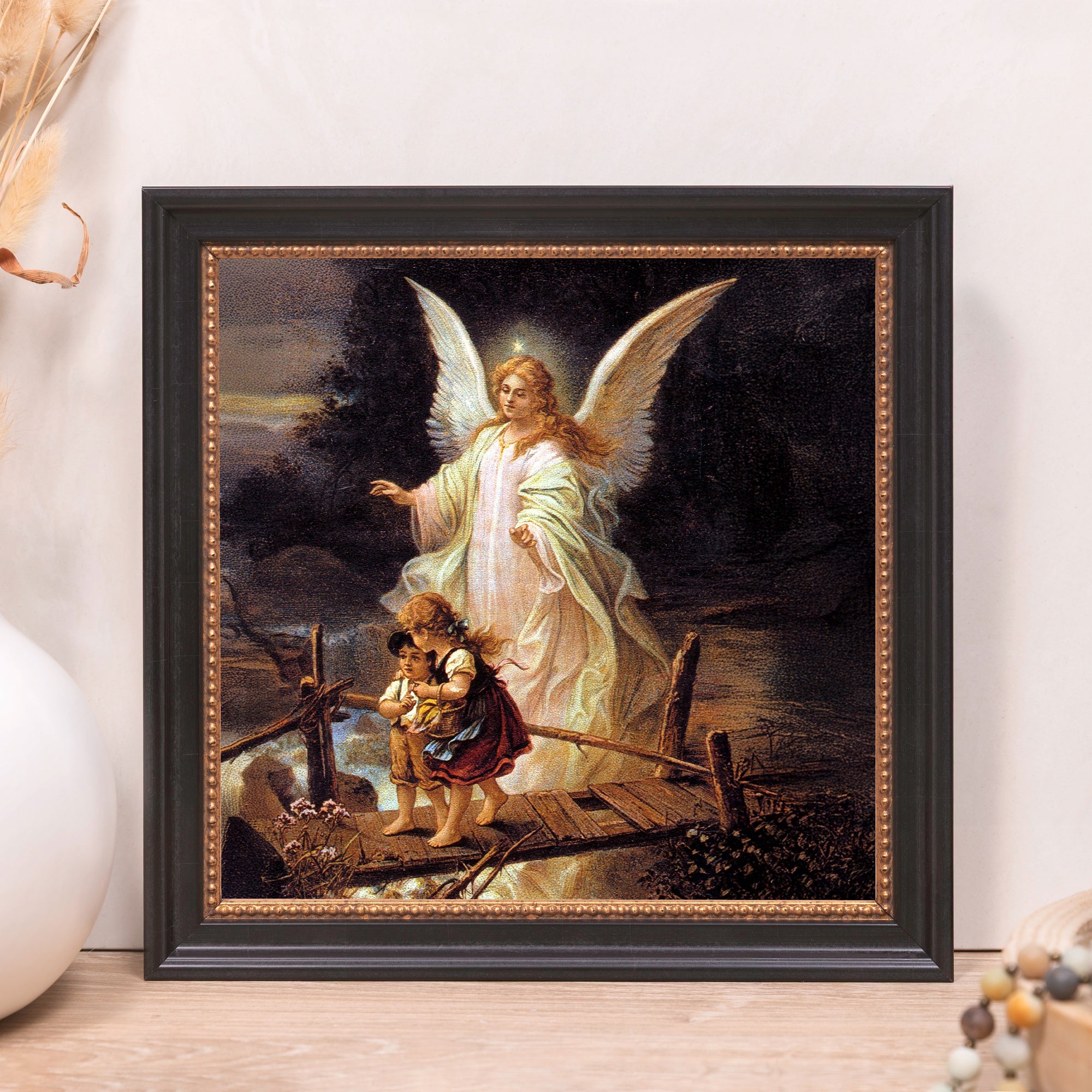 Framed "Guardian Angel" print; traditional religious art with black frame and gold accents.