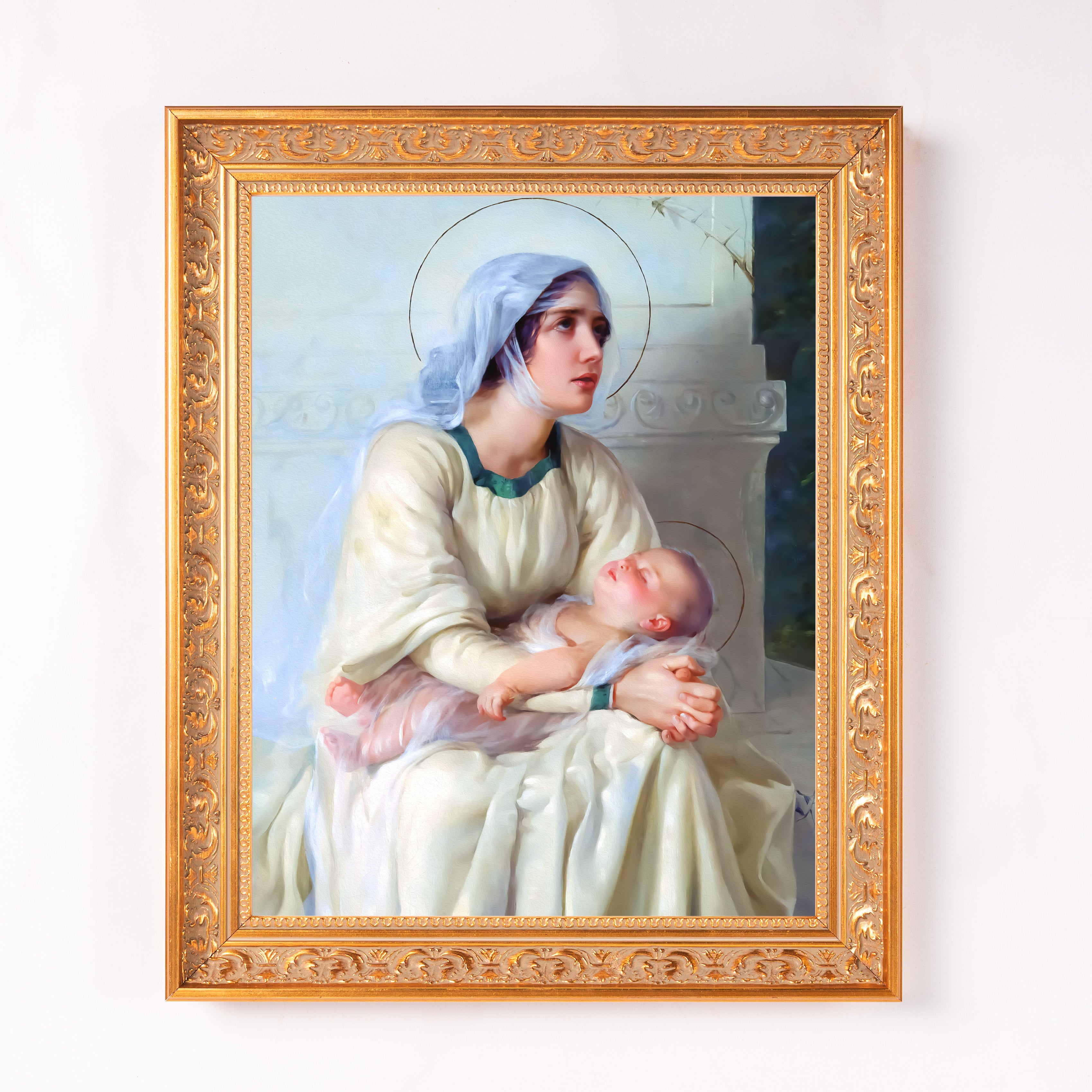 Framed painting of Mary and baby Jesus in white robes with a gold frame.