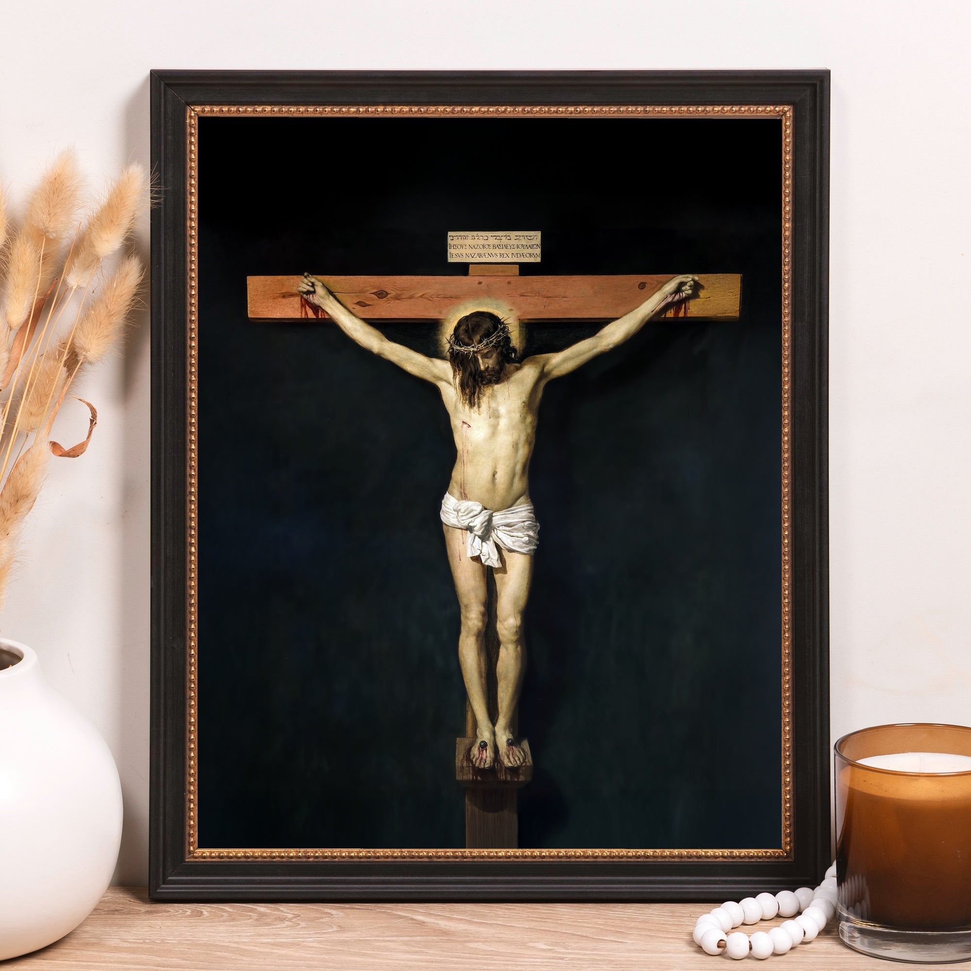 Framed painting depicting the crucifixion of Jesus with a dark background and black frame.
