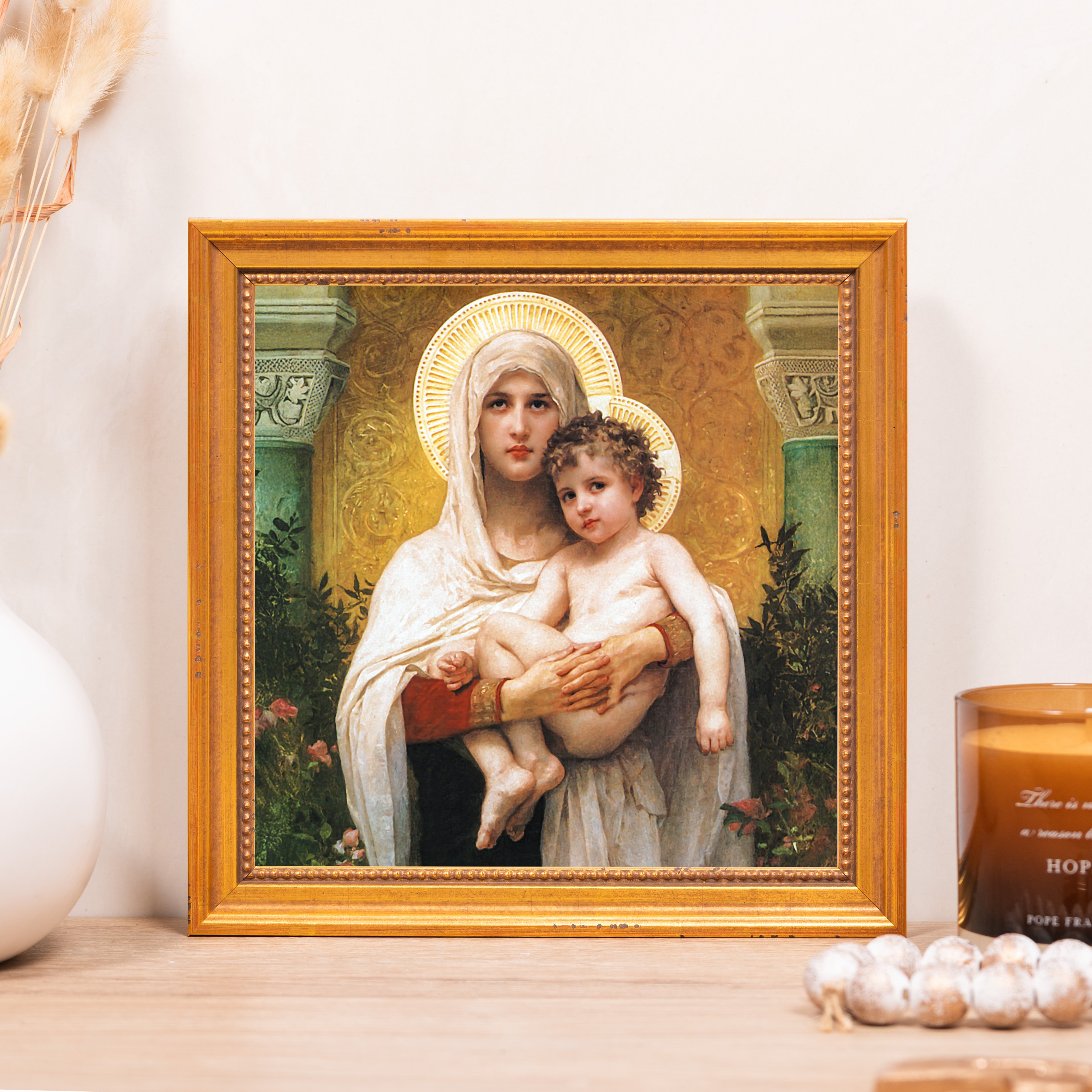 Framed artwork of Madonna and Child with golden halos, in a detailed gold frame.