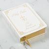 White, hardcover Holy Bible with gold engraved personalization and gilded pages.