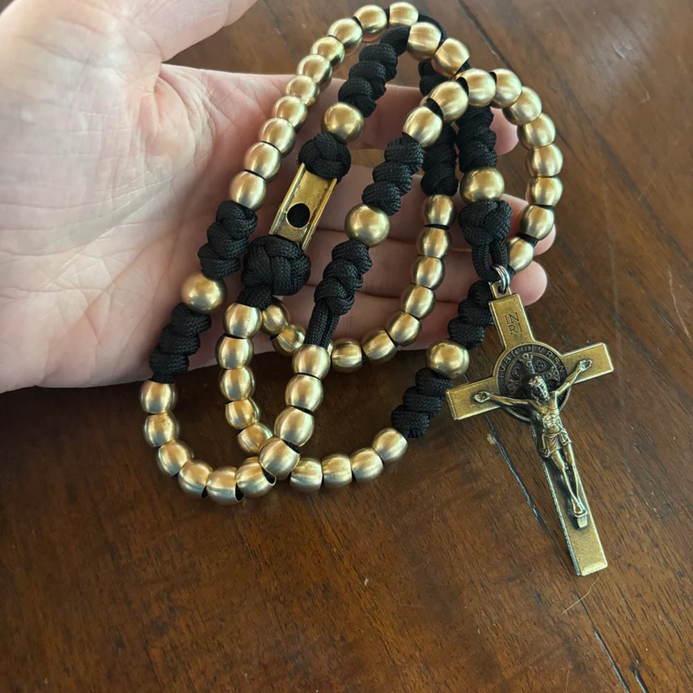 Religious rosary with gold beads, black knotted cord, and a detailed metal crucifix.
