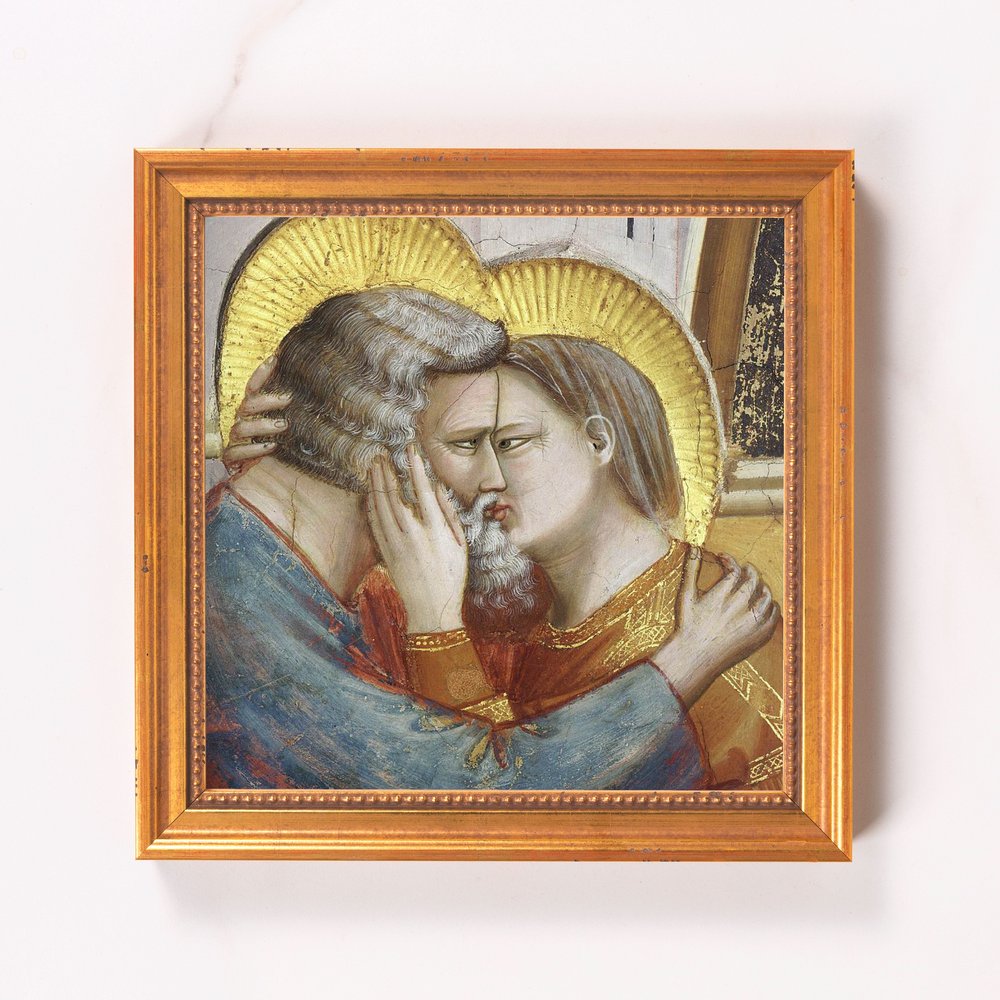 Framed painting depicts two figures embracing with gold halos in a Renaissance style.