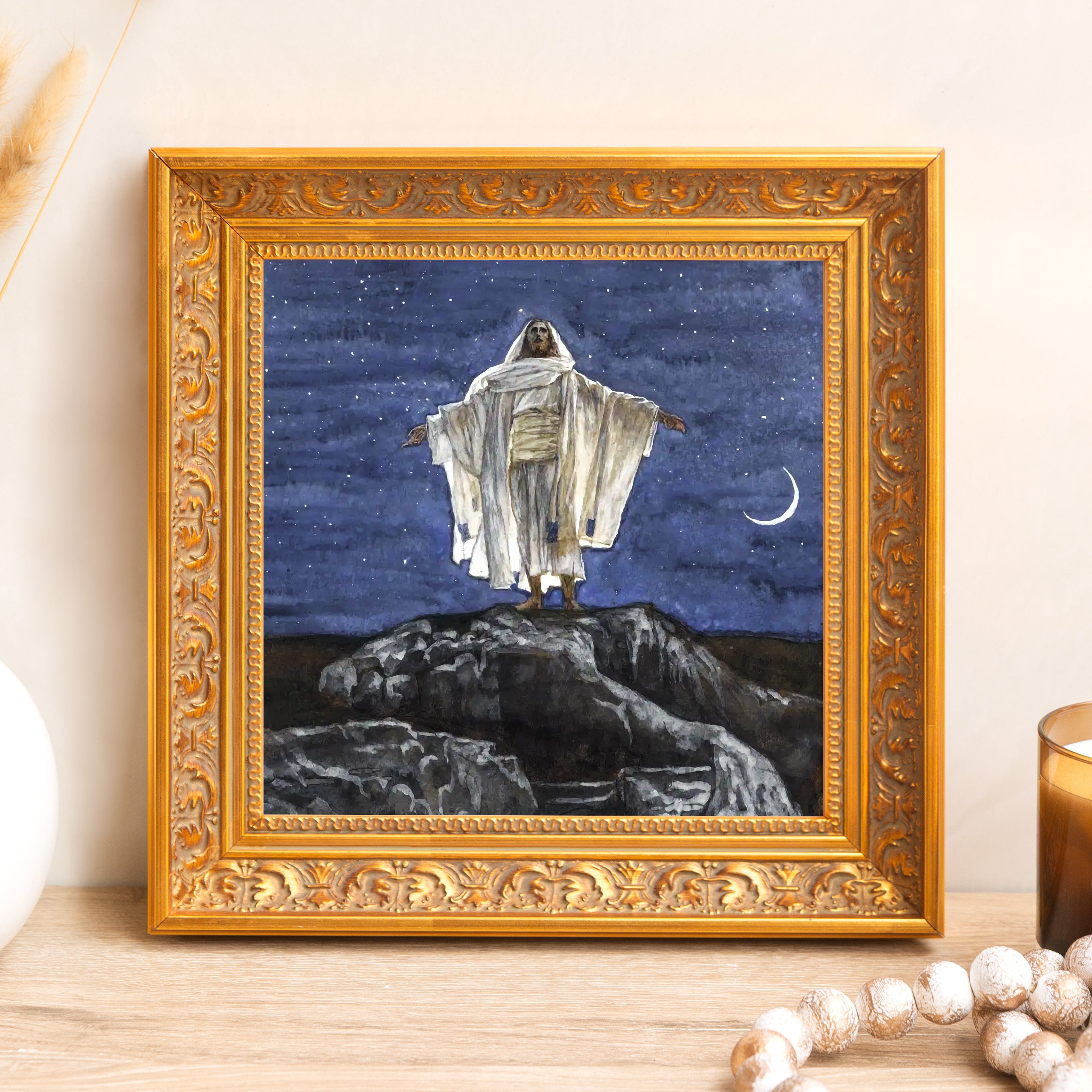 Framed painting of Jesus on a rock under a starry sky in ornate gold frame.