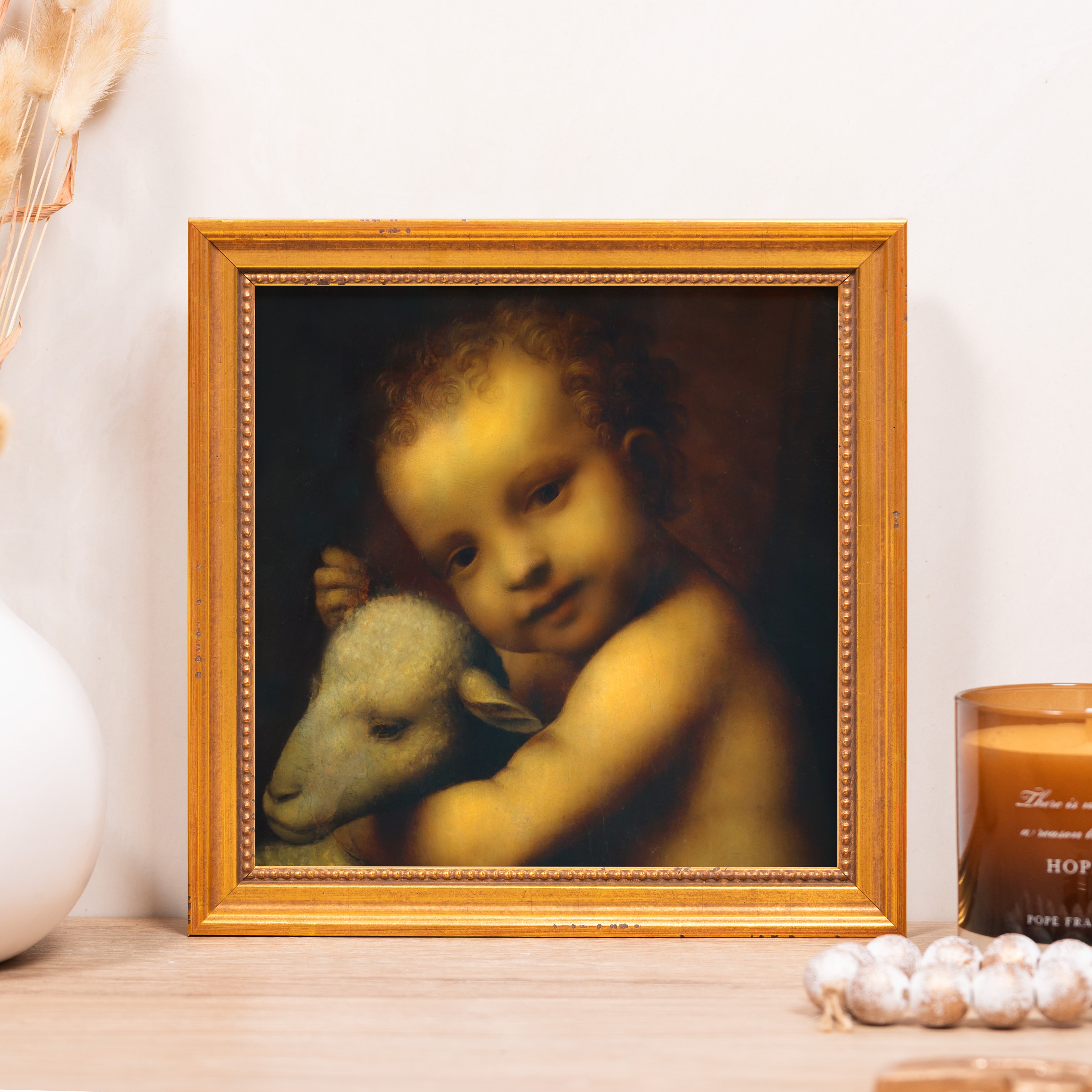 Framed oil painting of baby Jesus and lamb with a gold frame.