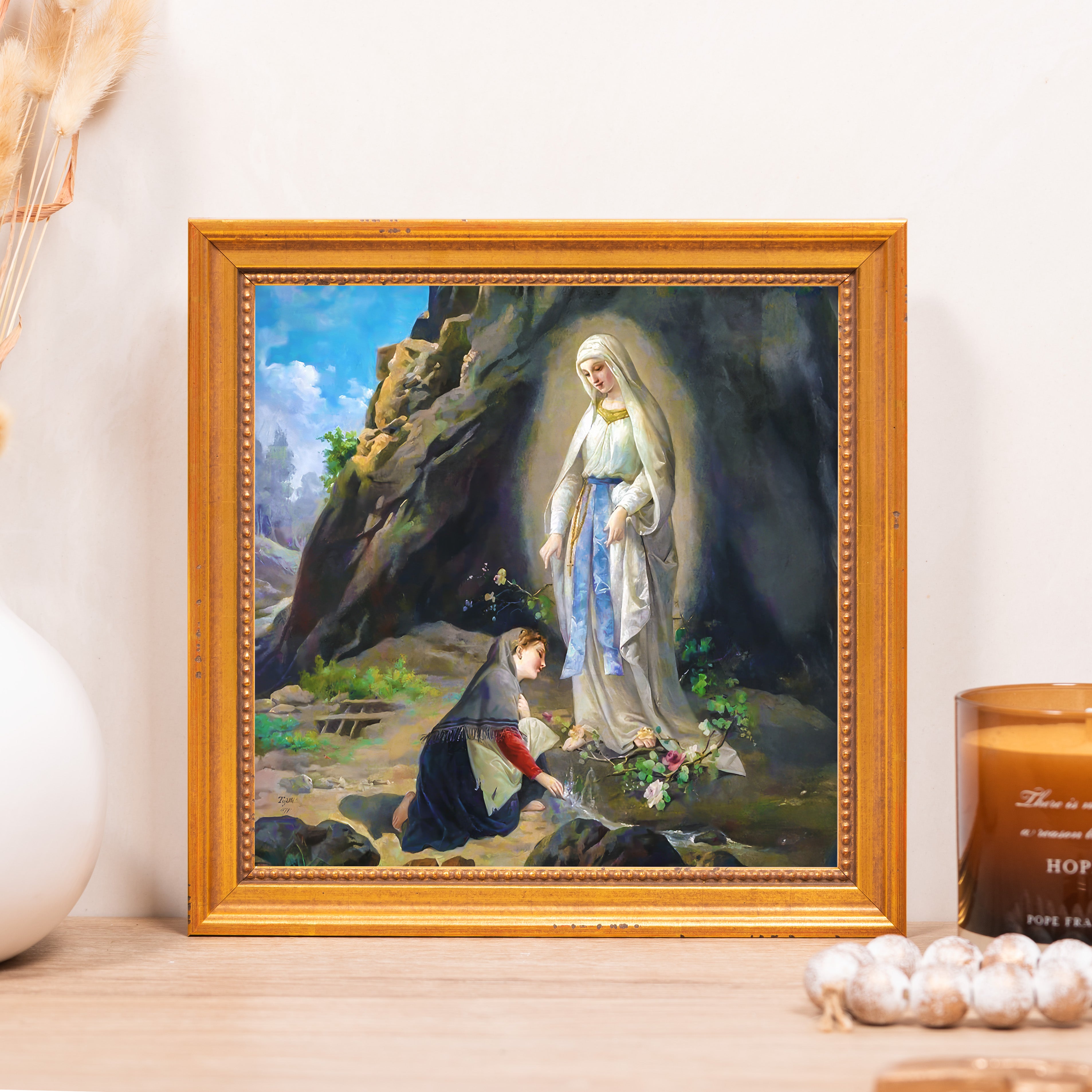 Framed print depicts Saint Bernadette and the Virgin Mary in Lourdes with a textured, gold frame.