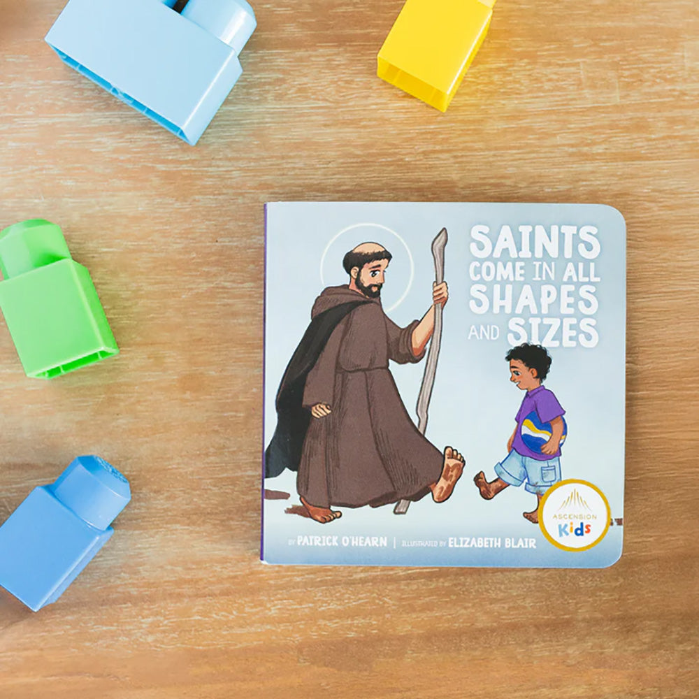 "Saints Come in All Shapes and Sizes" board book with colorful cartoon illustrations on a light background.
