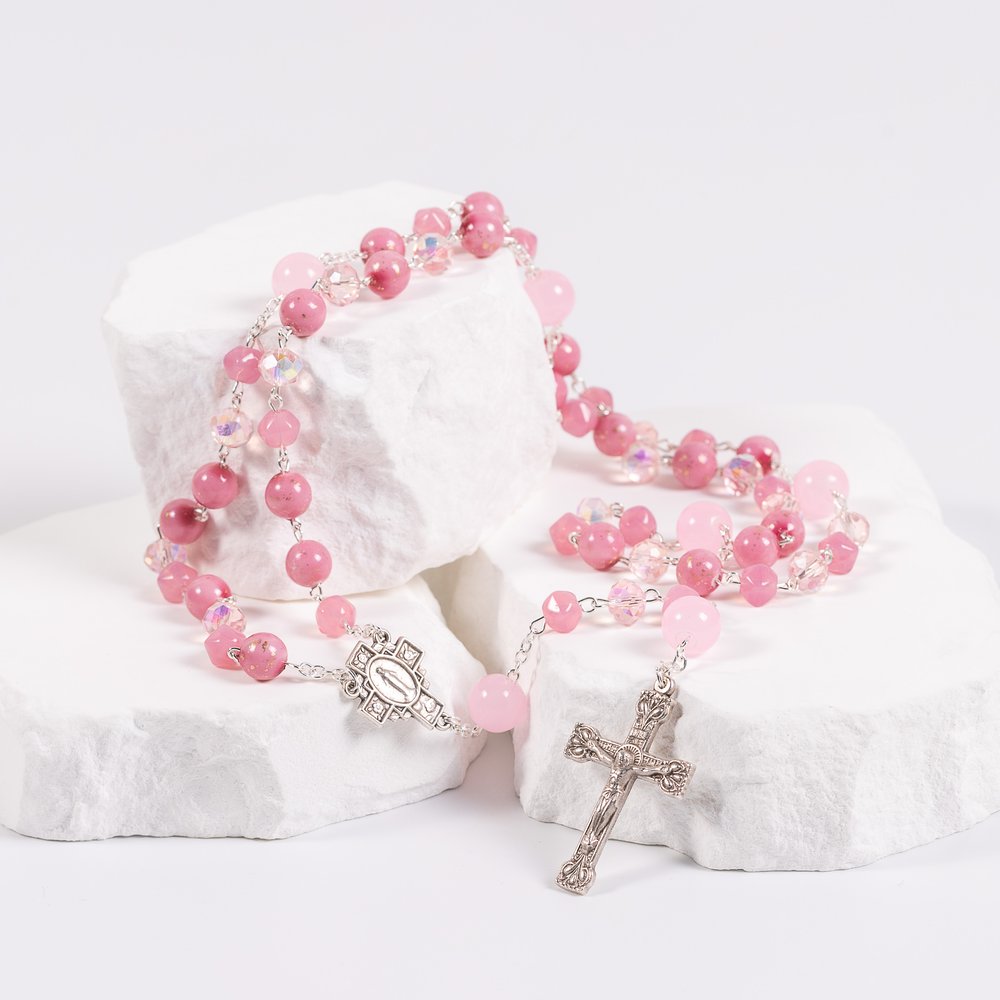 Pink rosary featuring rose quartz beads, clear crystals, and a silver crucifix.