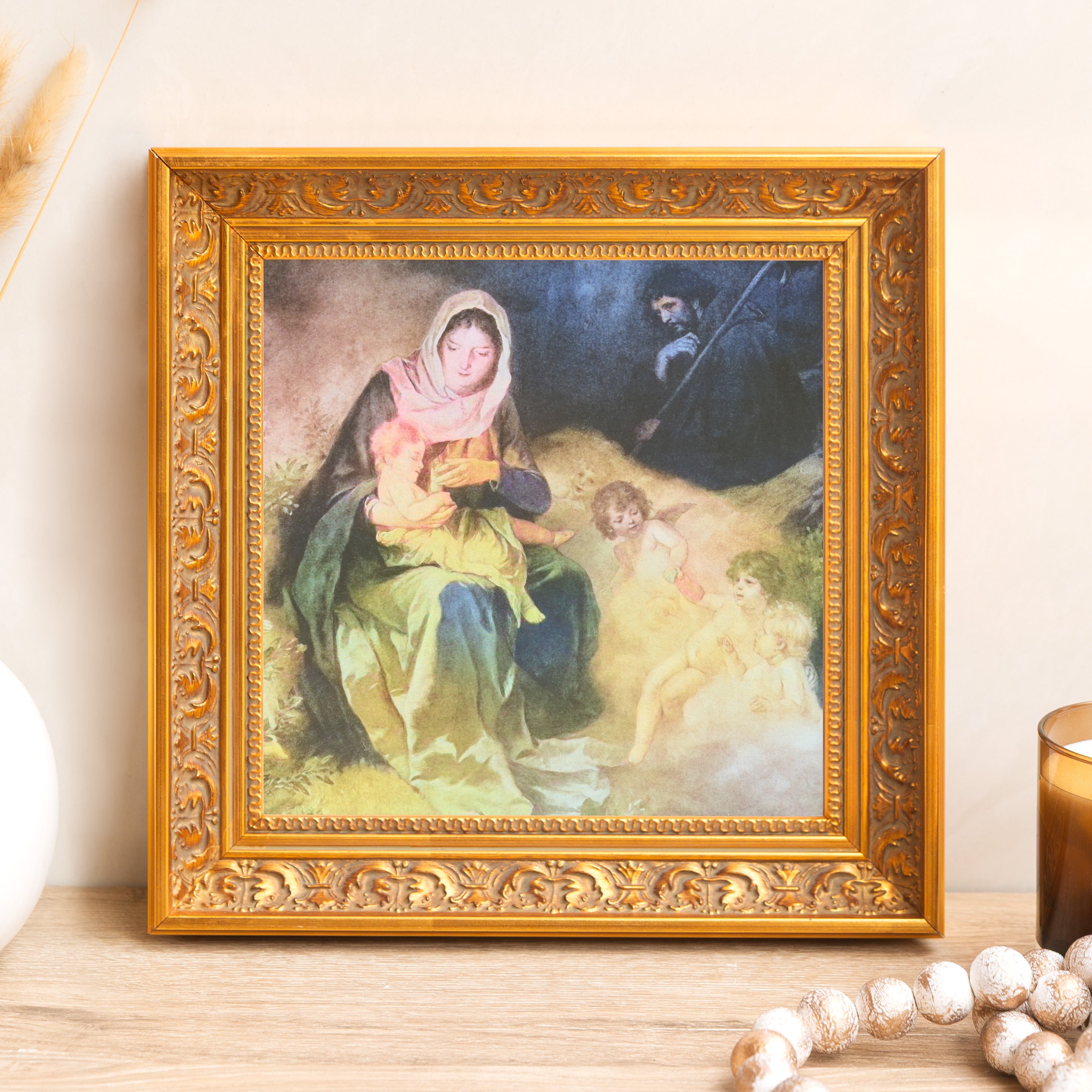 Framed religious art print depicting Mary, Joseph, and infant Jesus, with gold ornate frame.