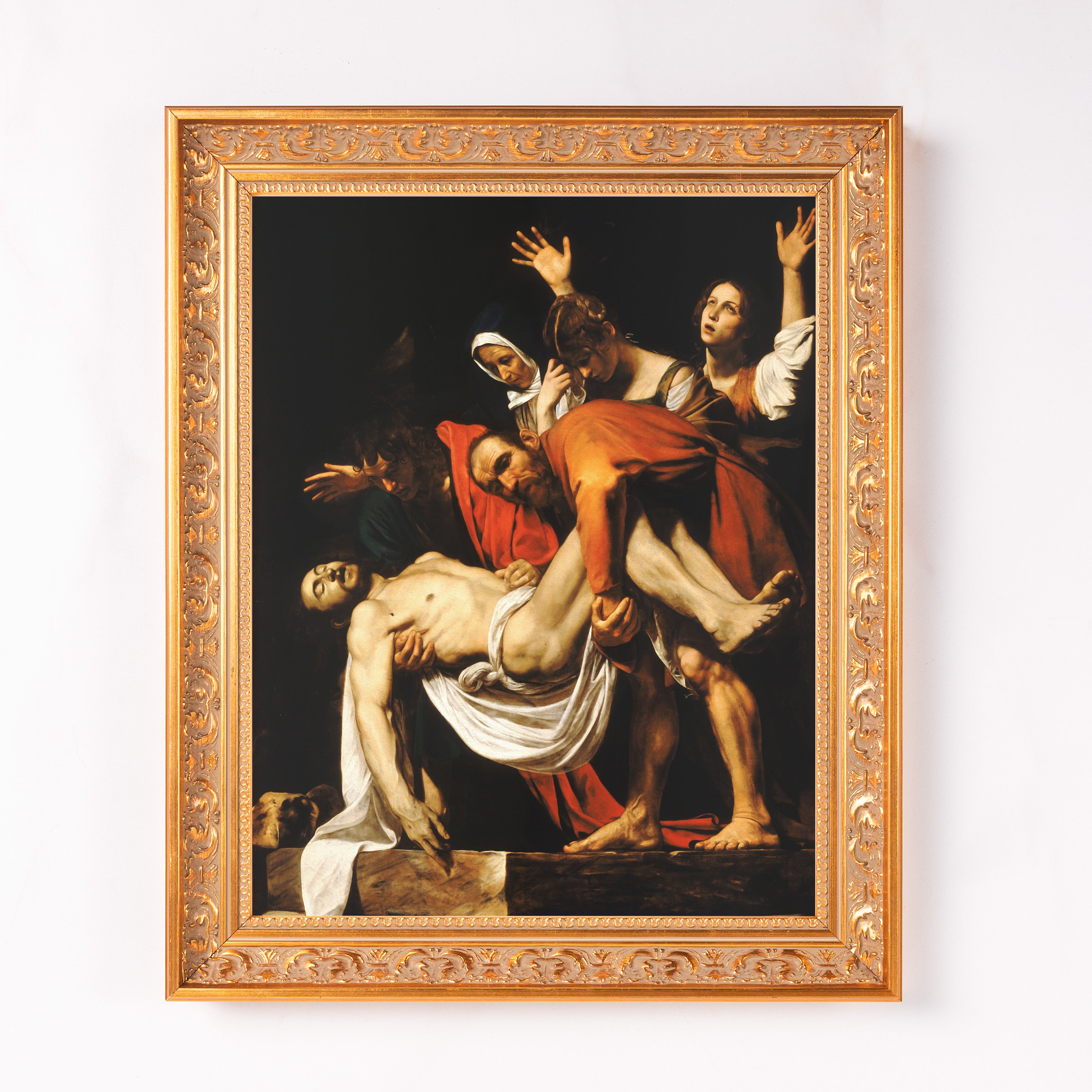 Framed reproduction art print of "The Entombment of Christ" with a gold ornate frame.