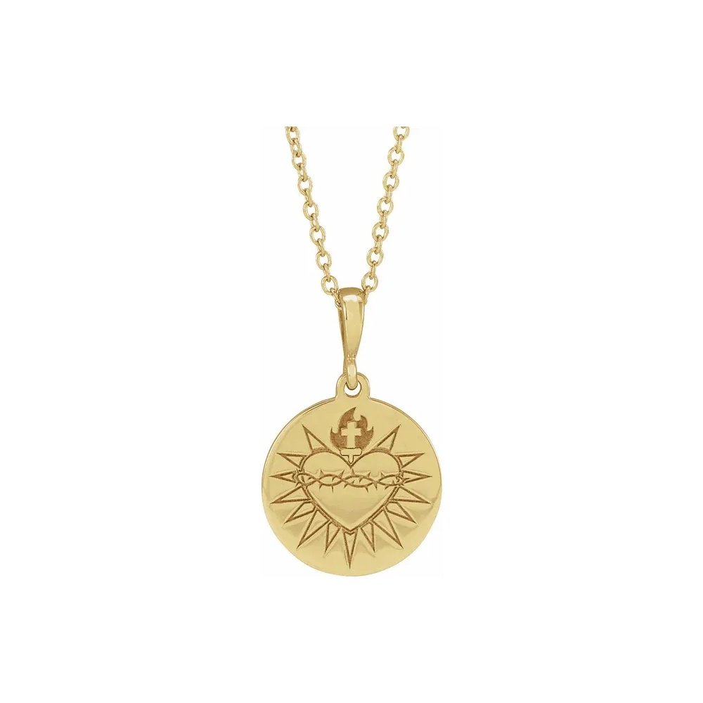 Gold pendant necklace with circular medallion featuring a heart with a crown of thorns design.