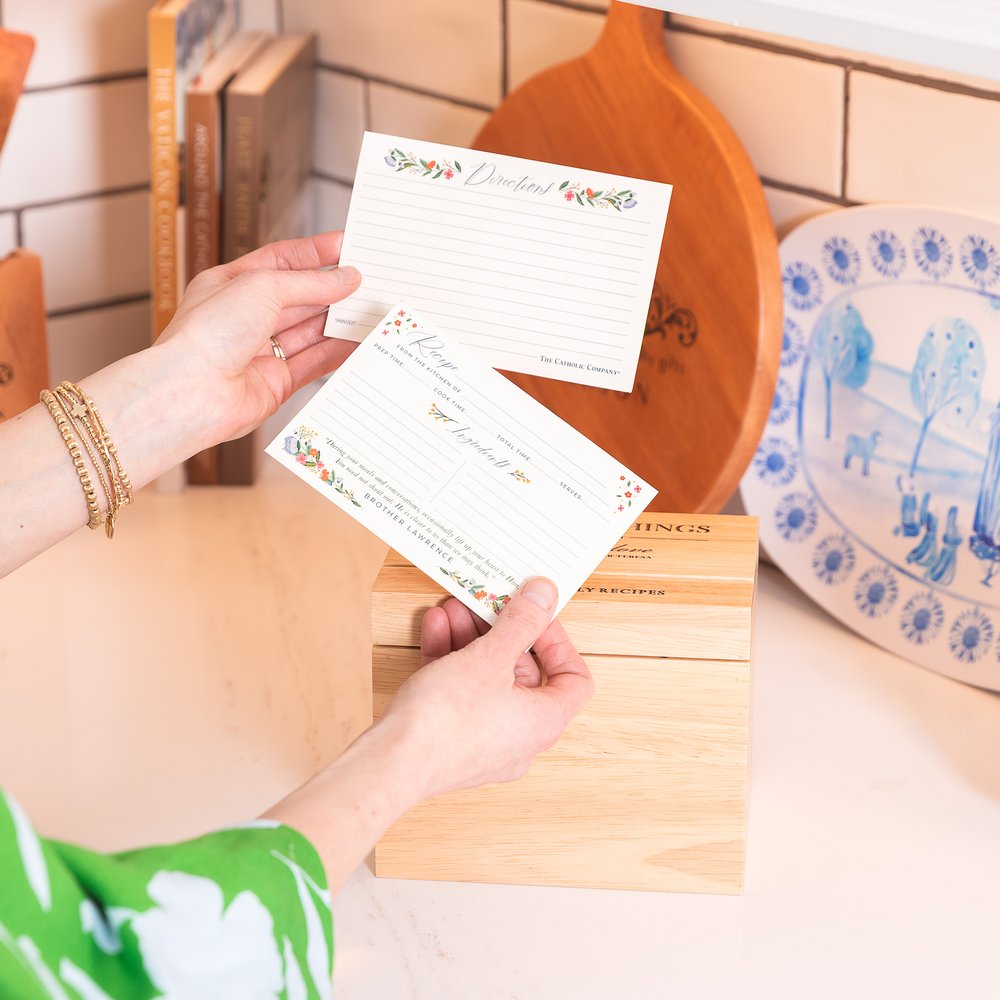 Floral Recipe cards being placed in wooden recipe box, for organizing cooking recipes; traditional style.