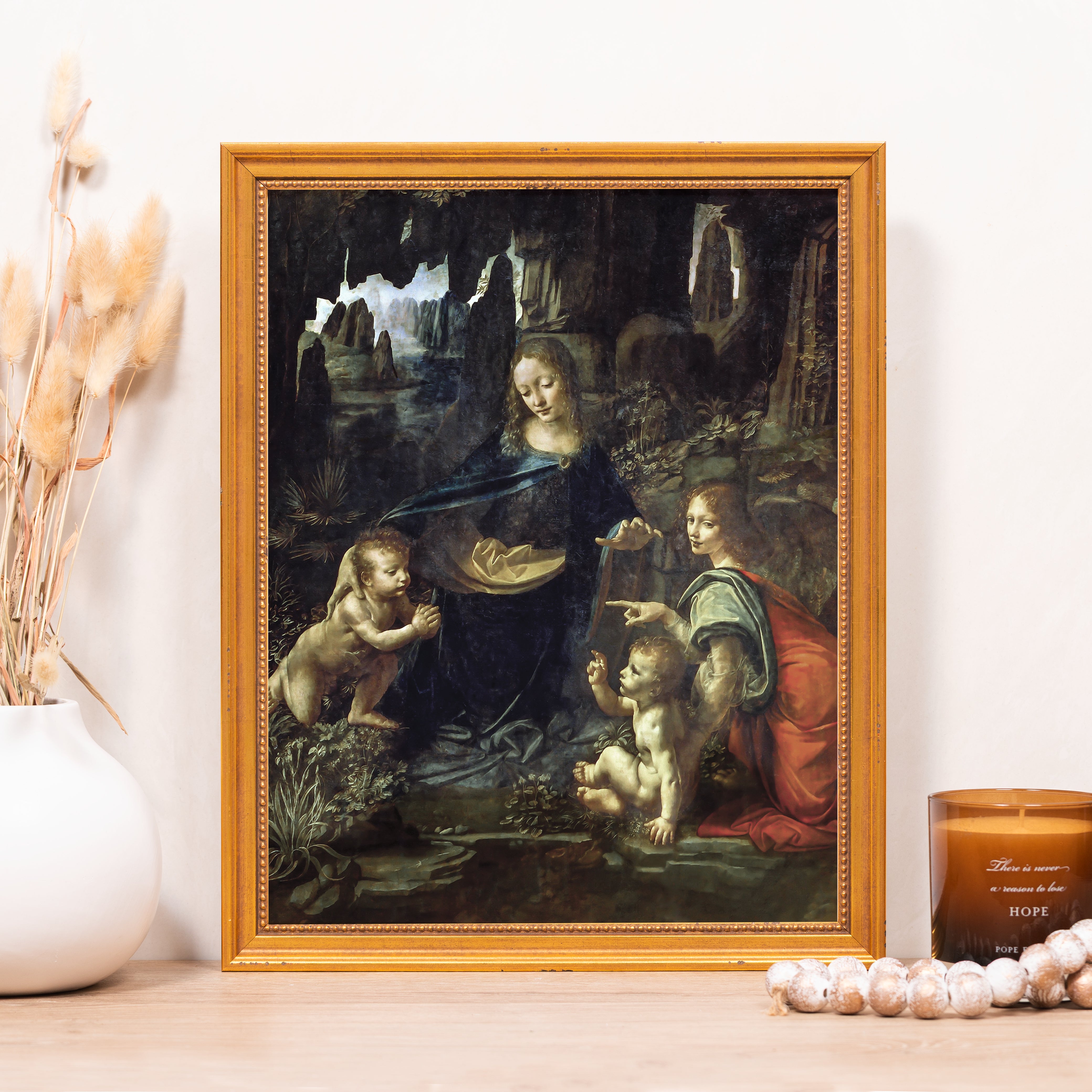 Framed "Virgin of the Rocks" print for home decor, featuring a gold-tone frame and dark green oil painting style.