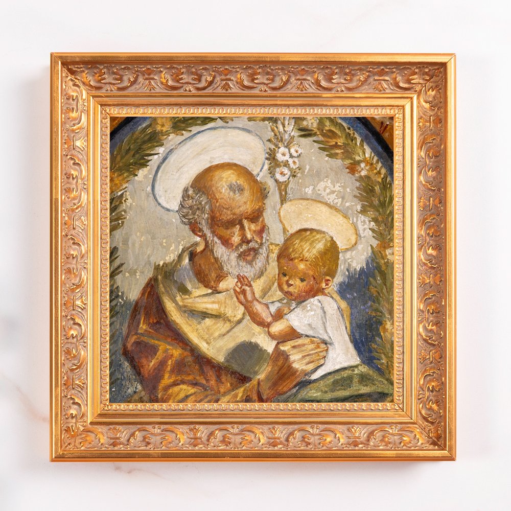 Framed painting showing Joseph and baby Jesus with halos, in painted style and ornate gold frame.