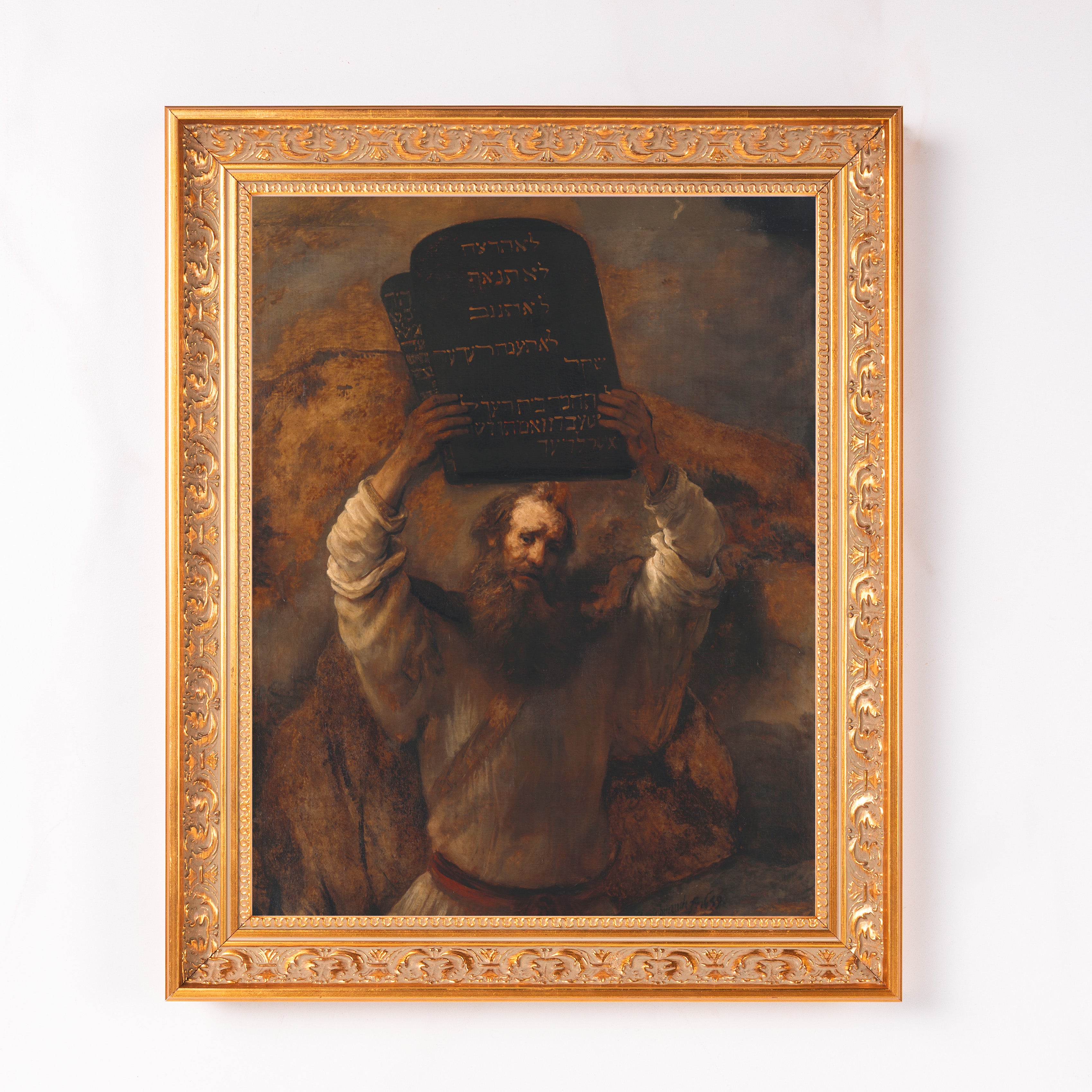 Framed portrait depicts Moses holding the tablets of the law, in earth tones, with an ornate golden frame.