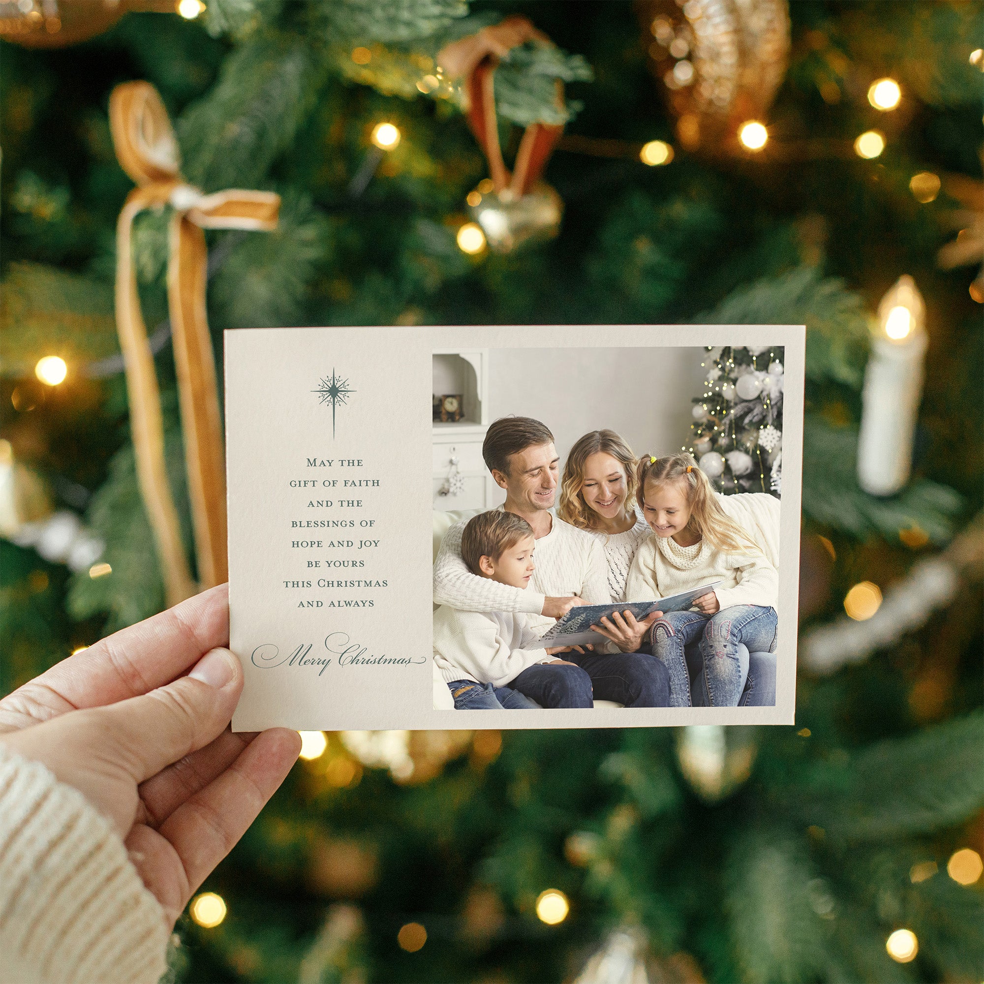Ivory Christmas card with photo of family reading a book and printed holiday message held in hand.