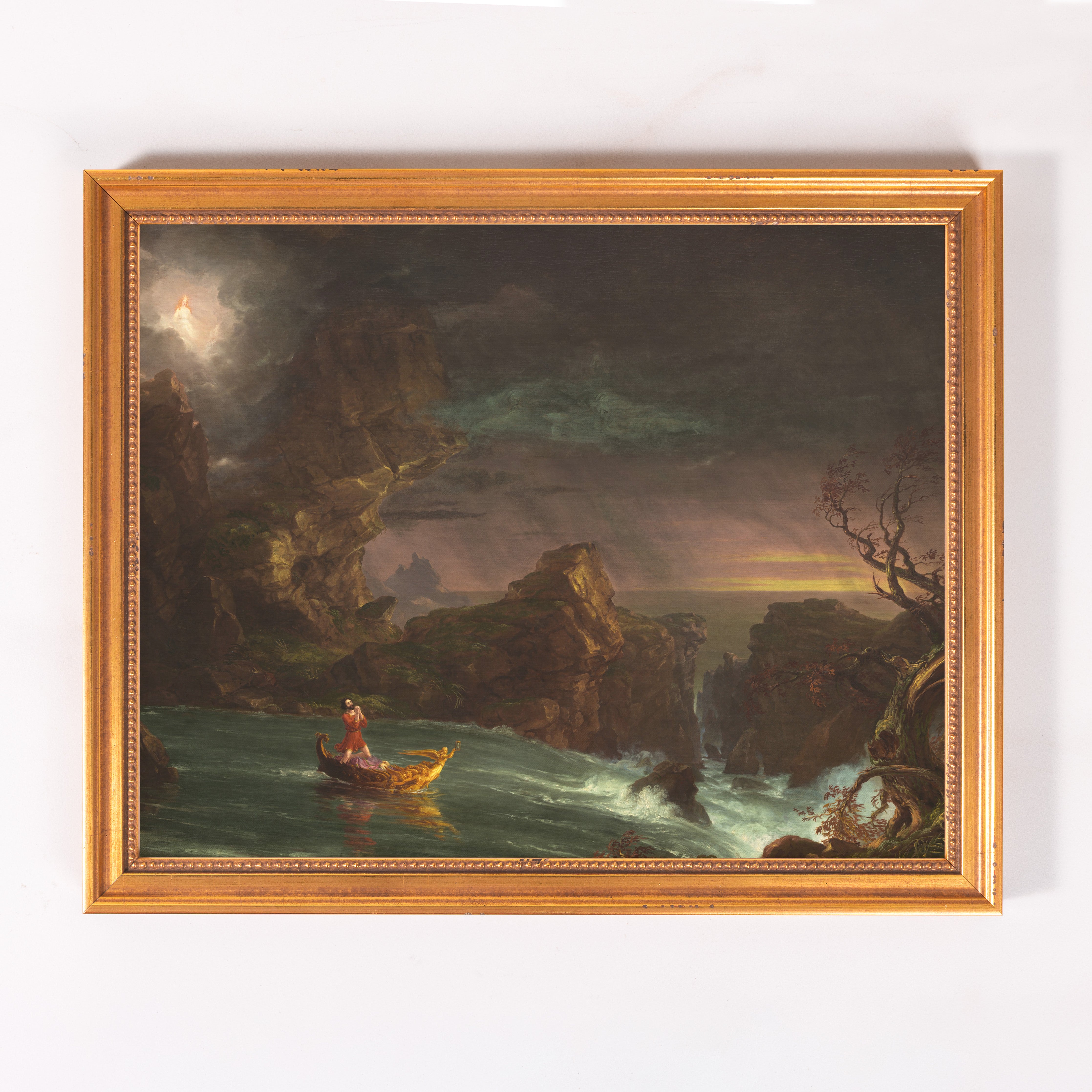 Framed oil painting depicting a storm, rocks, water, and a boat with figures.