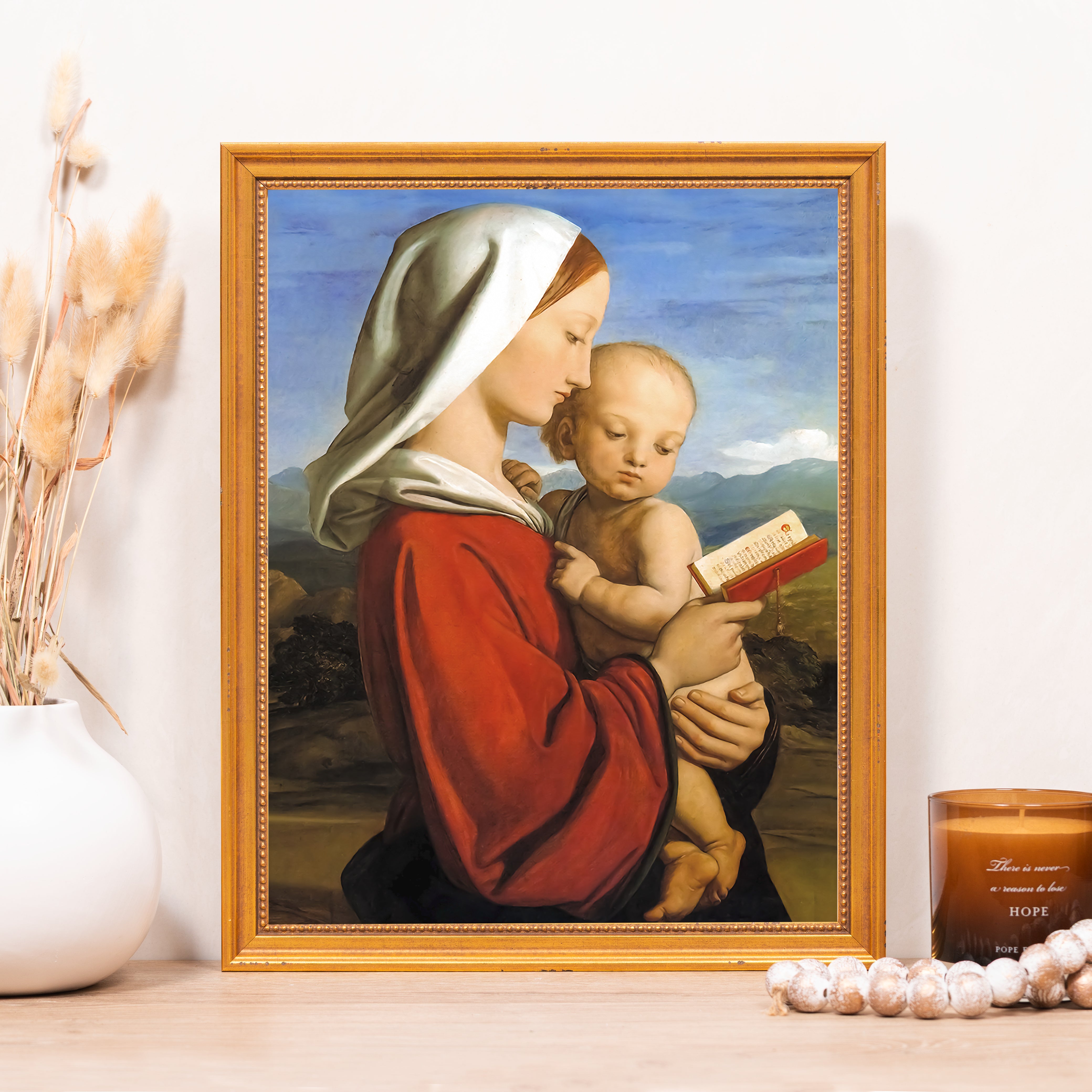 Framed painting, madonna and child holding book, with red robe and white headdress.