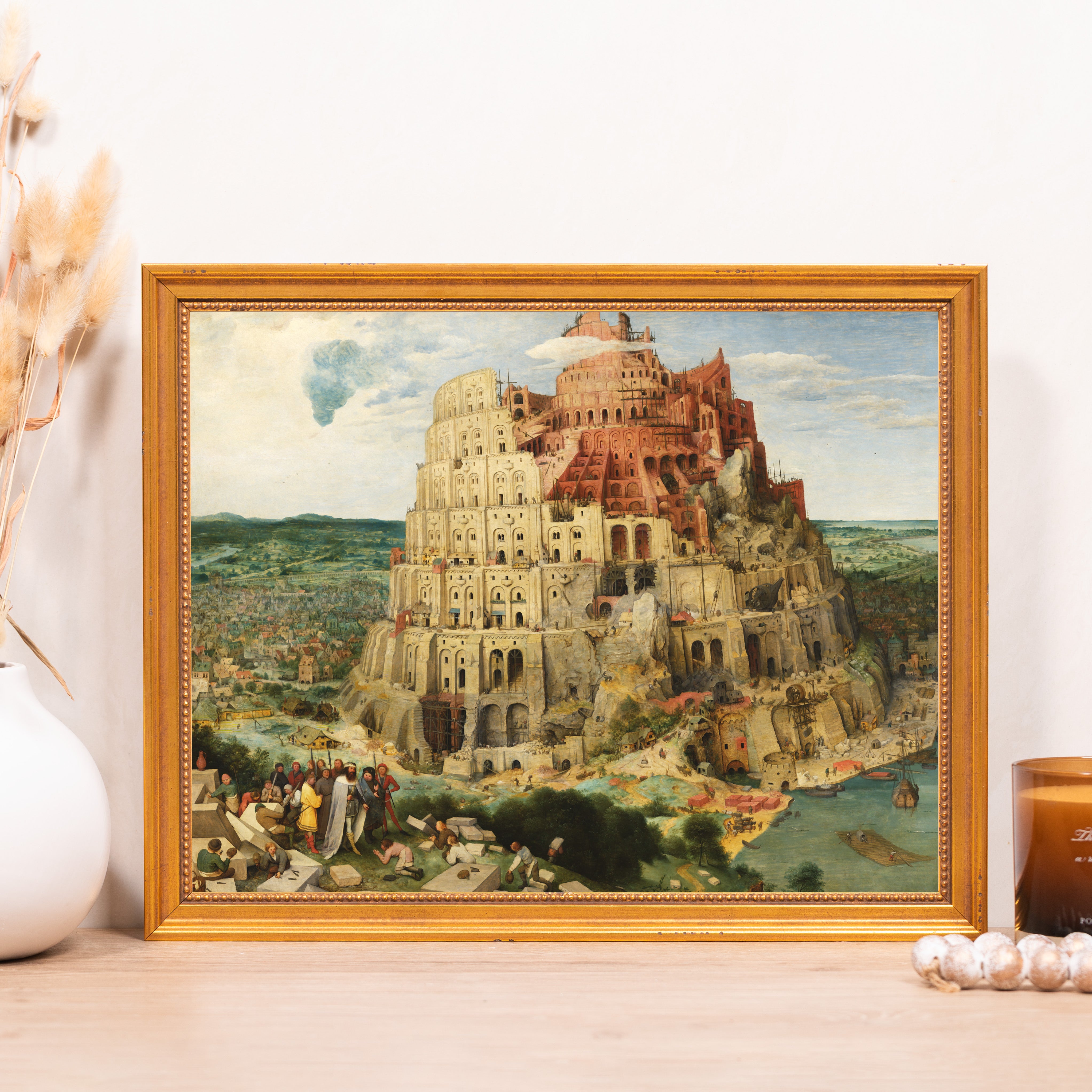 Framed Tower of Babel art print with a gold frame; painting shows unfinished structure in white and red.