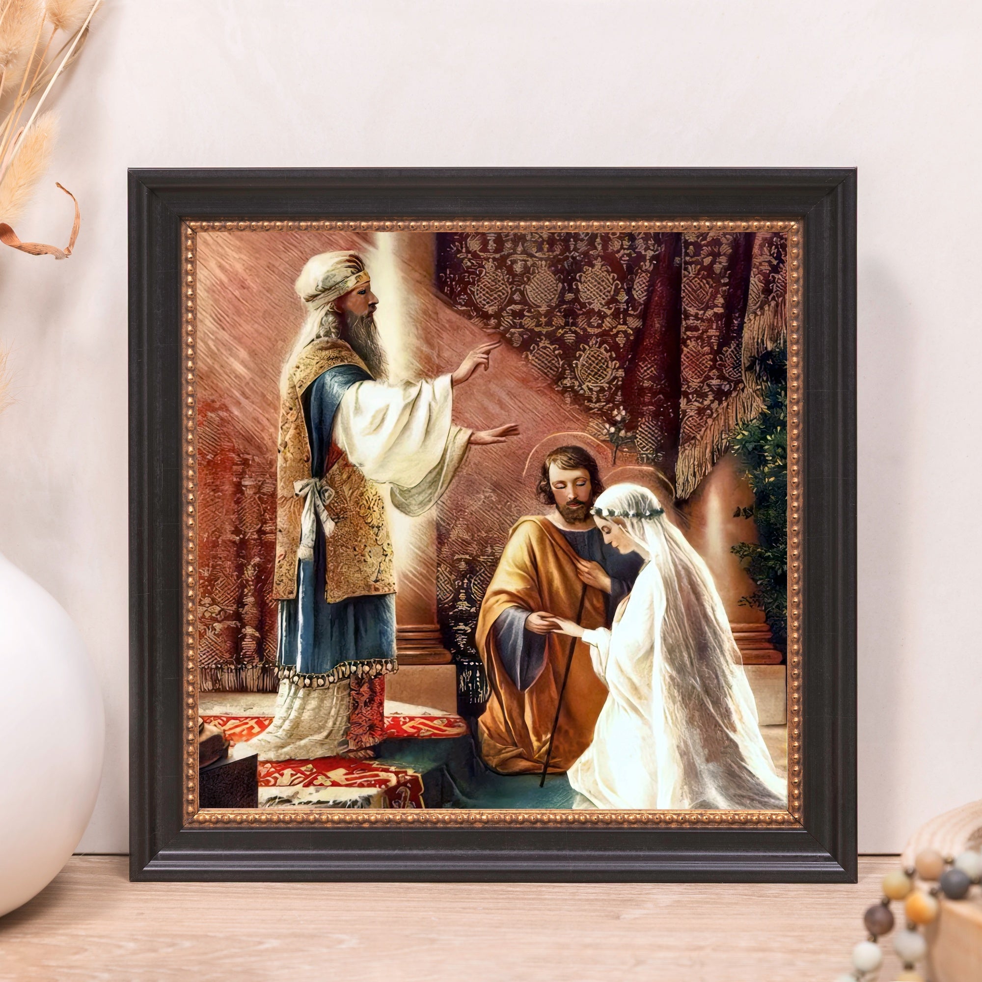 Framed marriage art, depicting a religious ceremony, gold tones with a black frame.