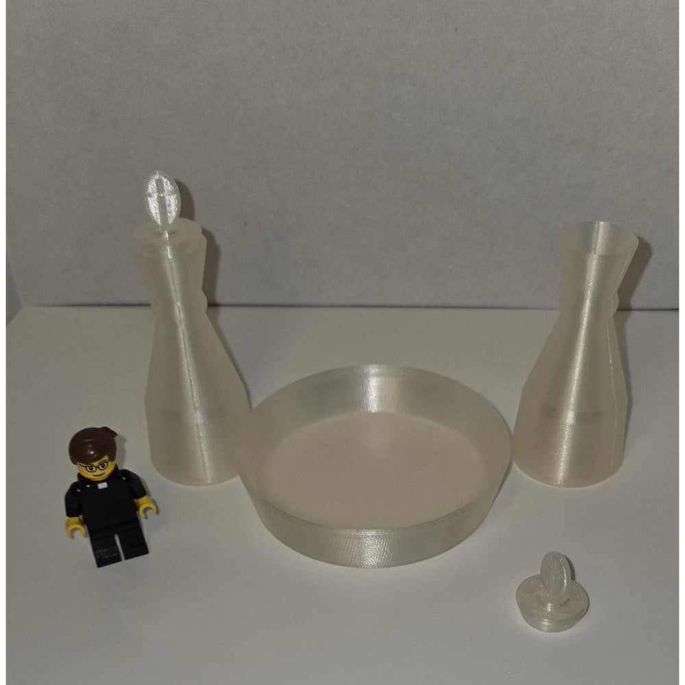 Miniature Catholic altar set includes chalice, paten, and crucifix made of translucent plastic with a Lego figure for scale.