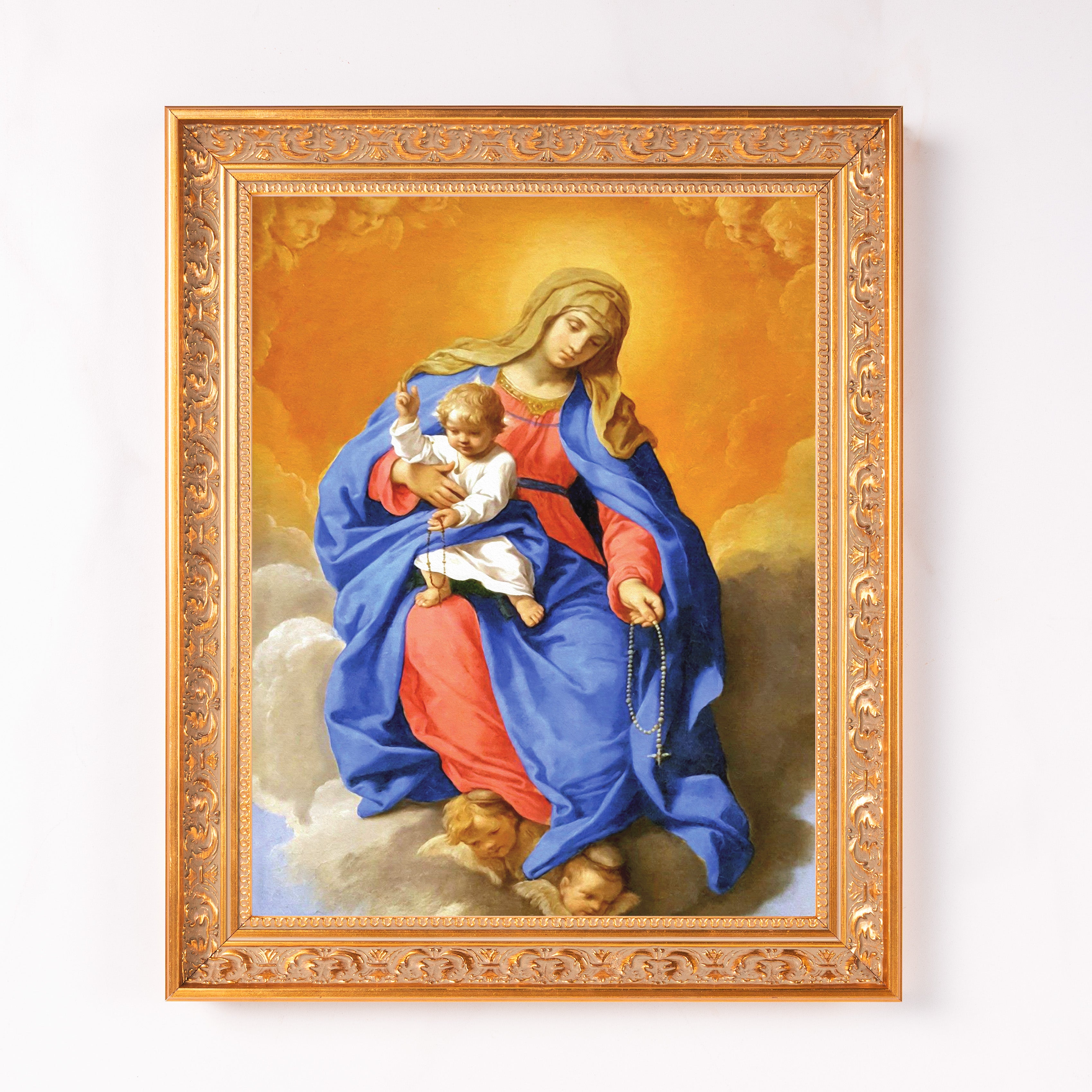 Framed painting of Mary holding baby Jesus wearing blue and red robes with rosary beads, ornate gold frame.