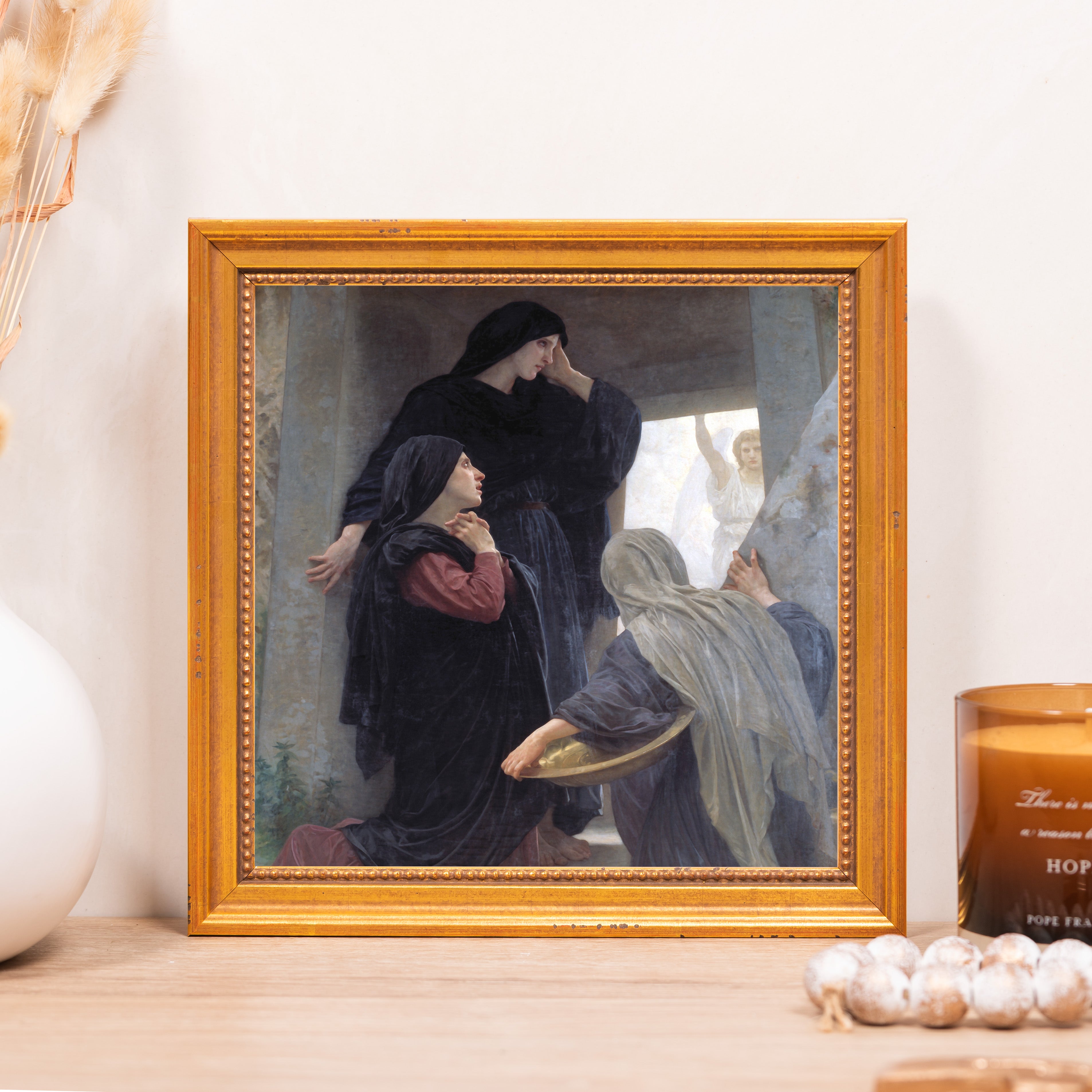 Framed painting of women at a tomb in somber robes with a gold frame.