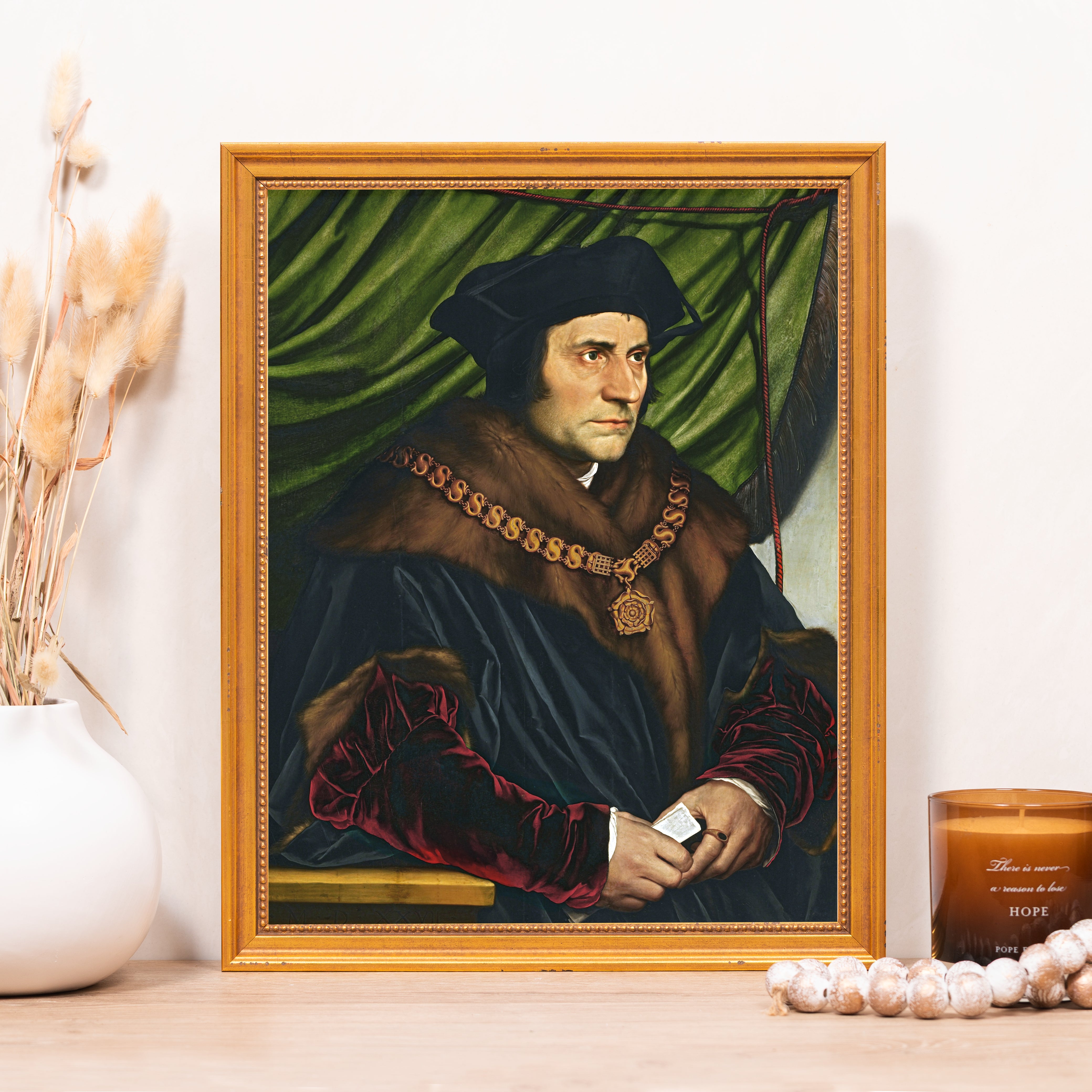 Framed portrait reproduction; Thomas More in black hat and gown with fur collar, in gold frame.