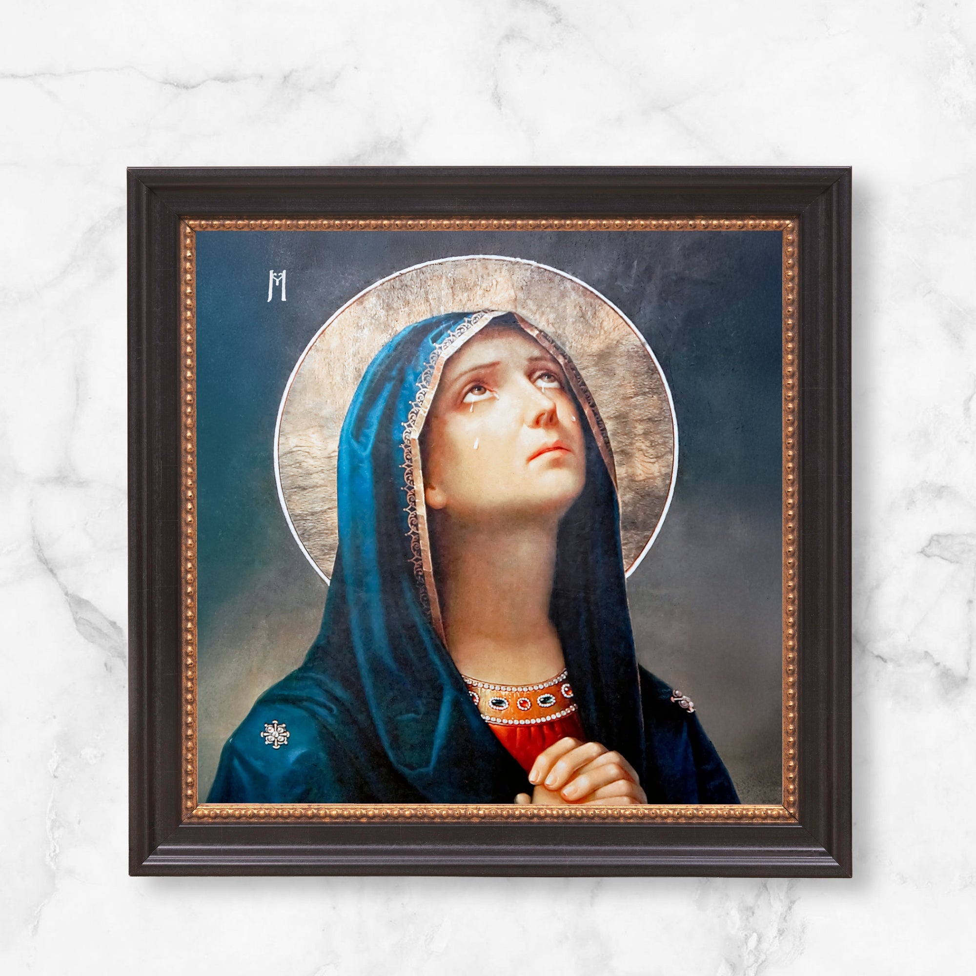 Framed Icon art depicting Virgin Mary in blue veil, looking upwards with tears on her face.