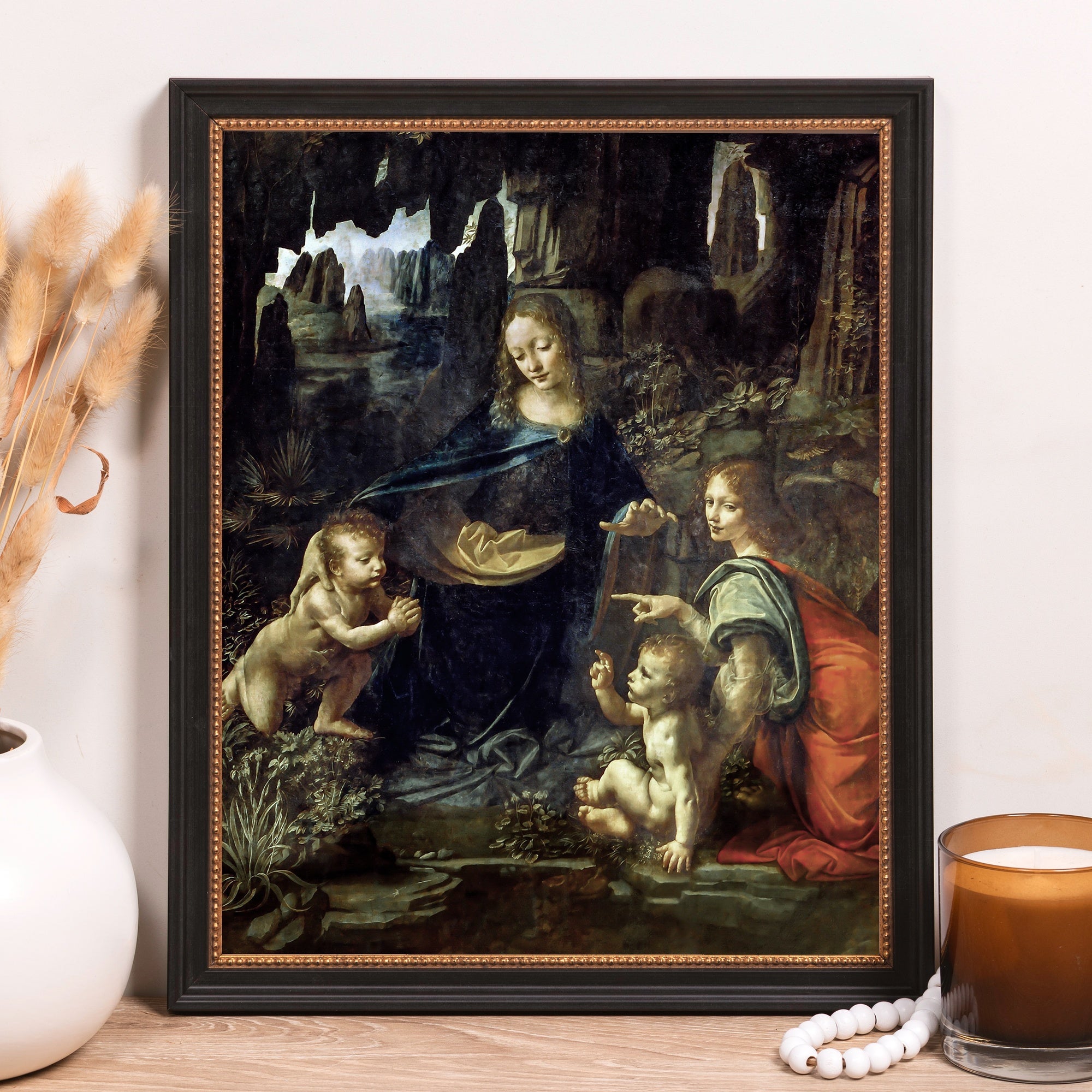 Framed print of a classical painting with dark cavernous background in black frame.